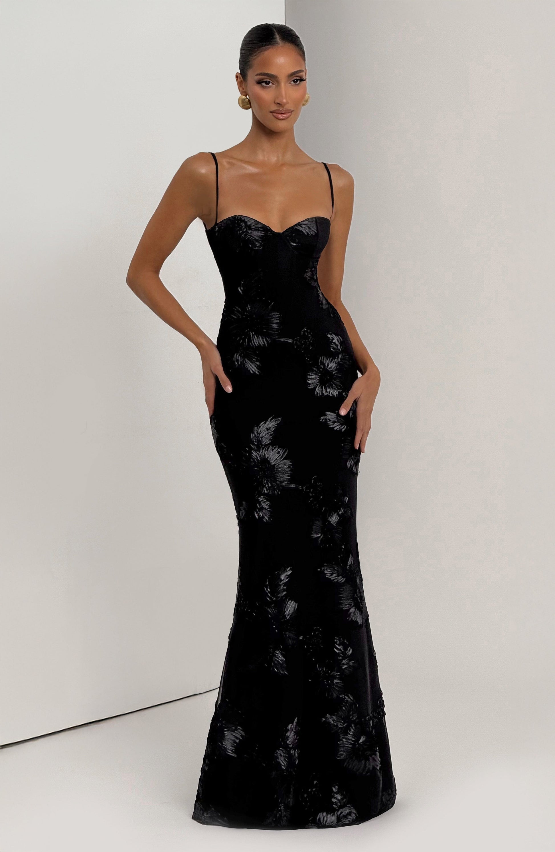 Front view of the black Celestina Floral Maxi Dress, showcasing the elegant sweetheart neckline and intricate floral patterns on the skirt.