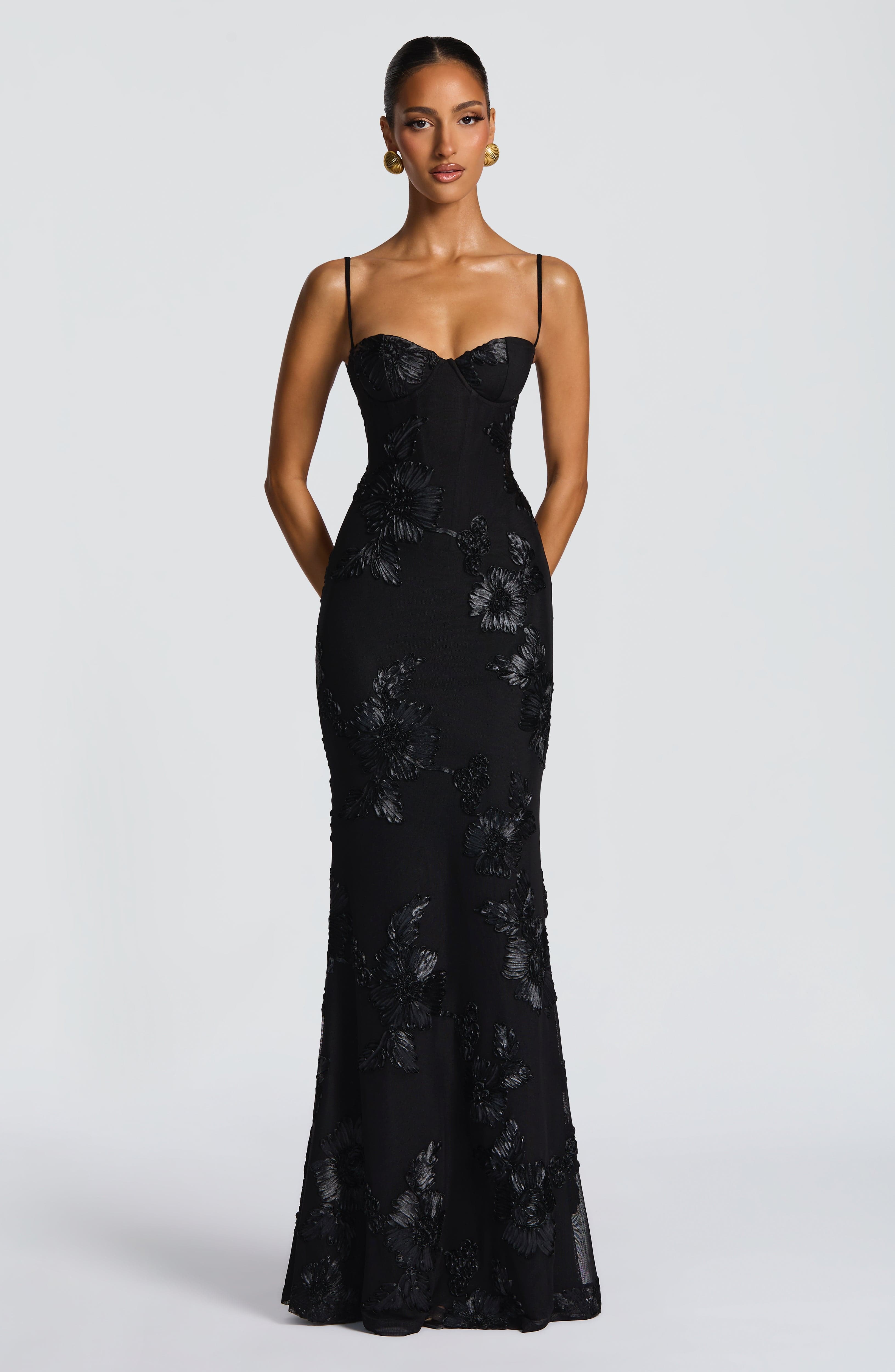 Front view of the black Celestina Floral Maxi Dress, highlighting the bustier bodice and flowing skirt with floral patterns.