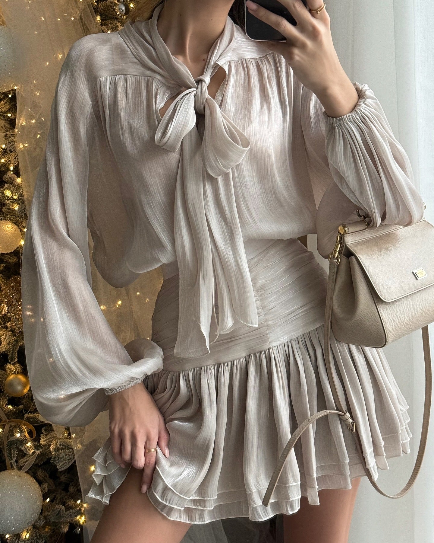 Detailed view of the shimmery fabric and elegant bow neckline of the Celia Bow Mini Dress.