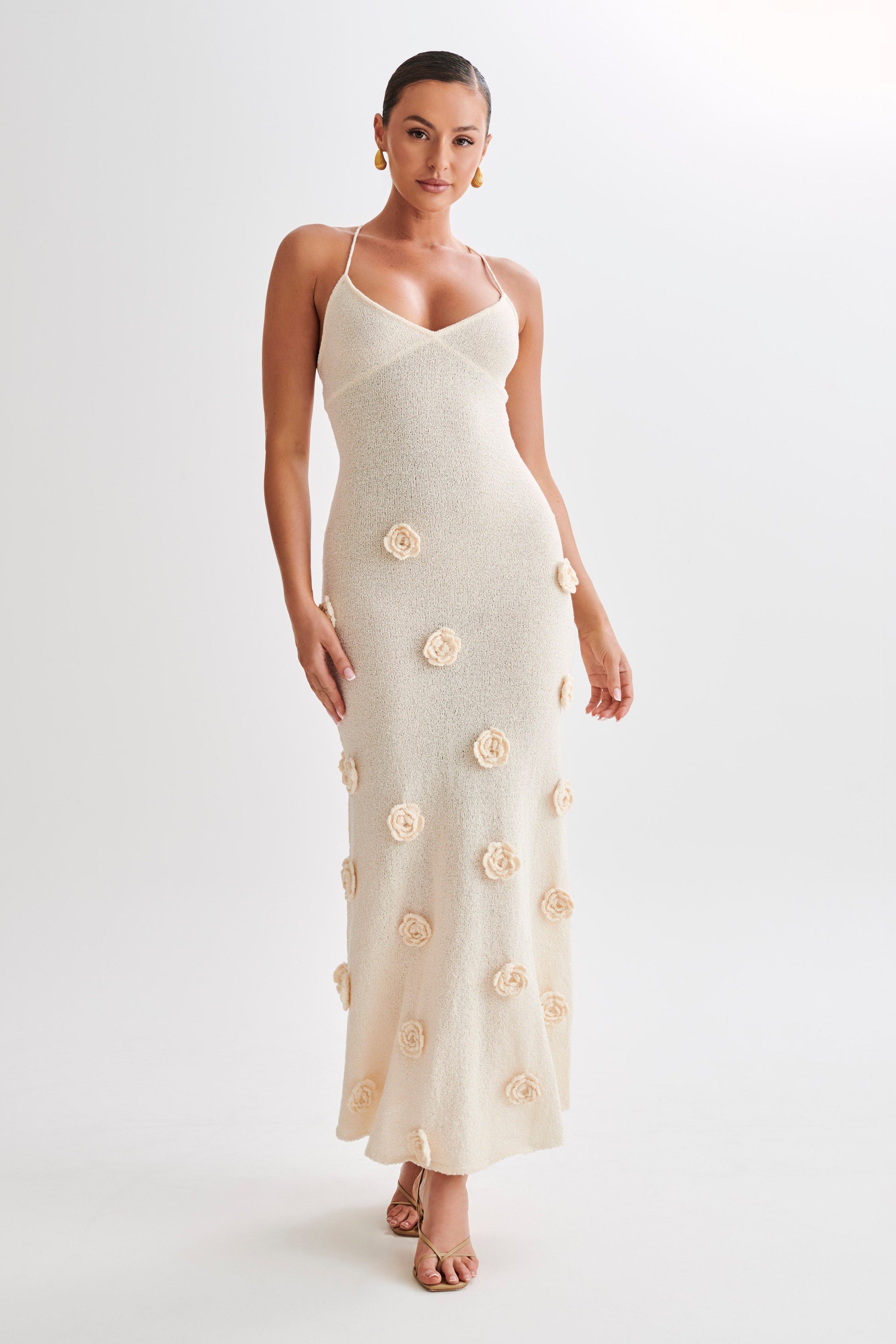 Full body shot of the Chelsea Floral Maxi Dress in a light cream color, showcasing the fitted silhouette and floral details.