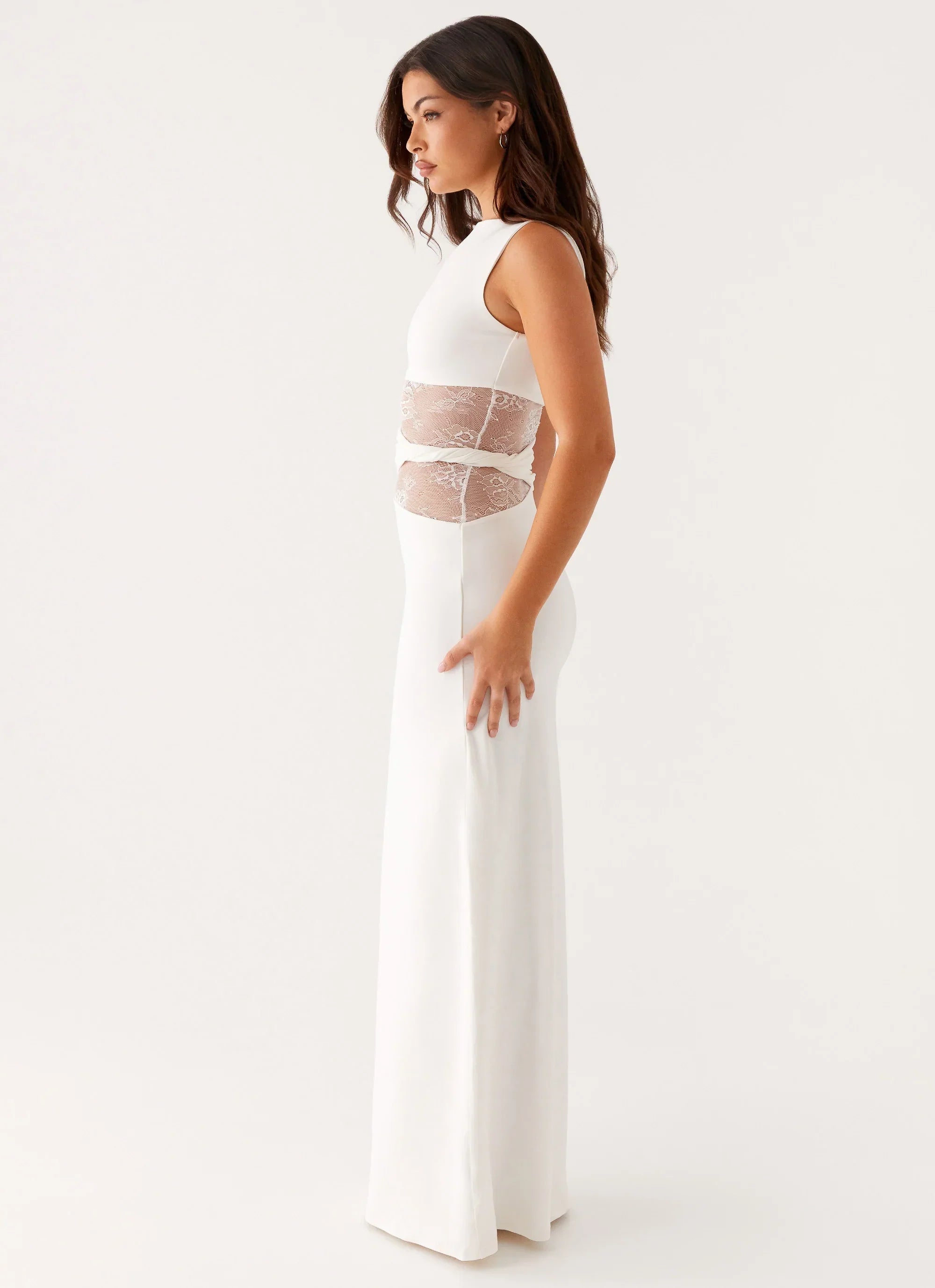 Side profile of a white Clarisse lace maxi dress, showcasing the sleeveless cut and lace waist
