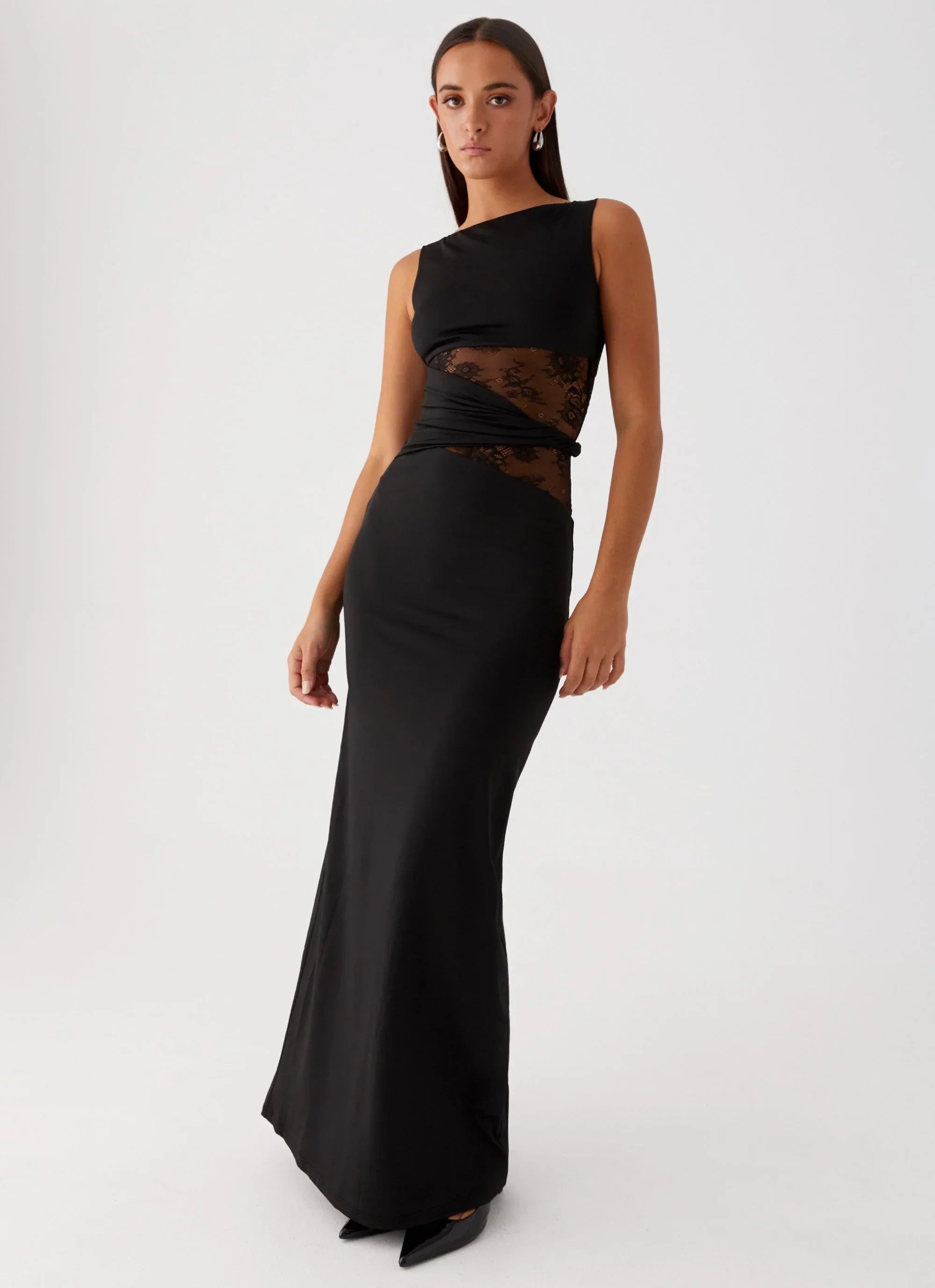 Black Clarisse maxi dress, sleeveless with boat neck and side lace cutouts, shown from a slight angle.