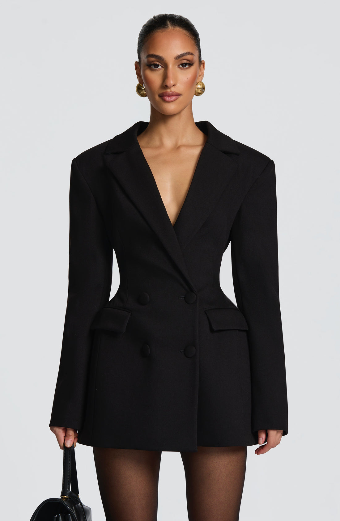 Front view of a white double-breasted blazer mini dress with peak lapels and two rows of buttons.
