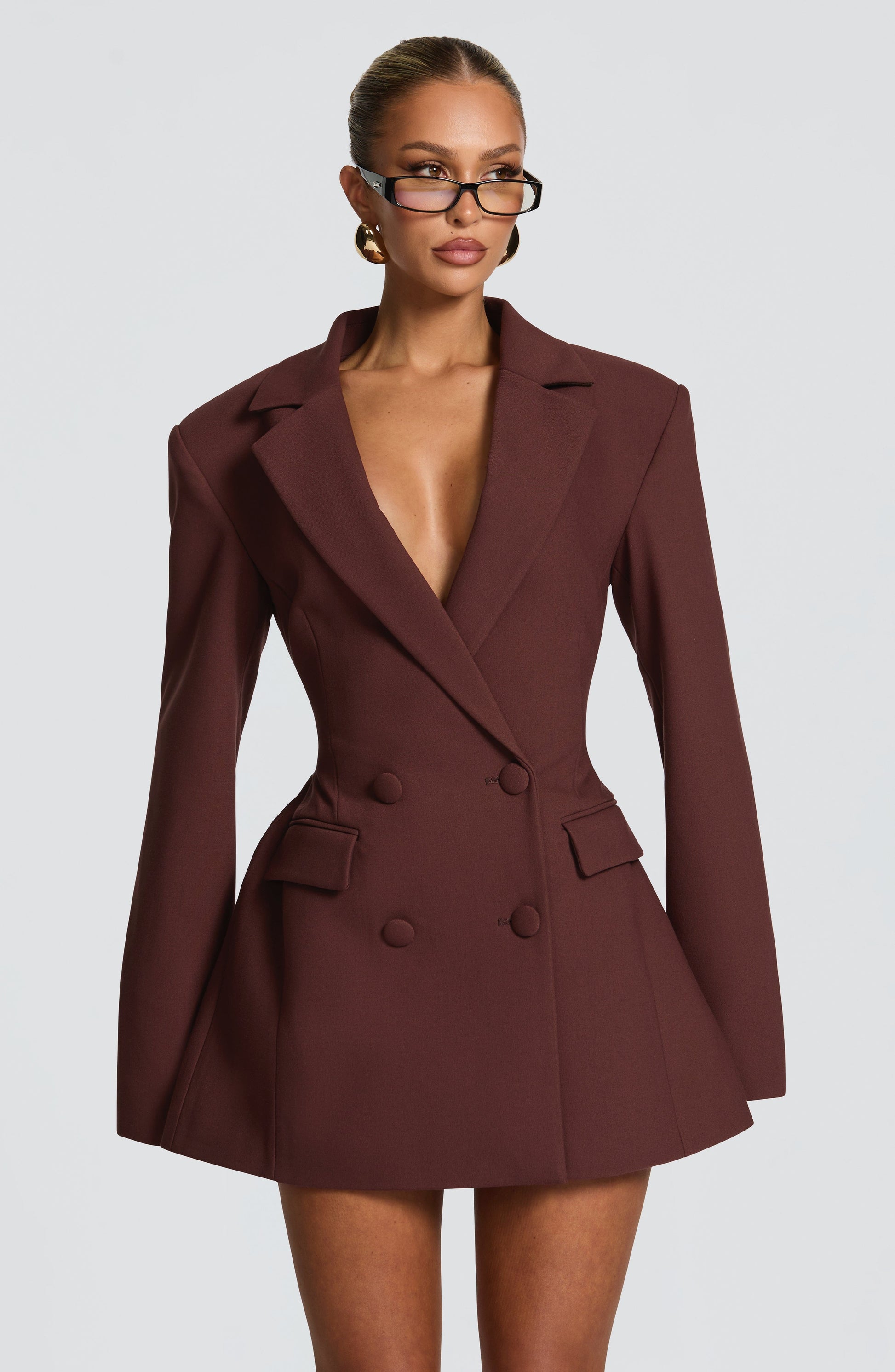 Front view of a dark brown double-breasted blazer mini dress featuring a tailored fit and prominent buttons.