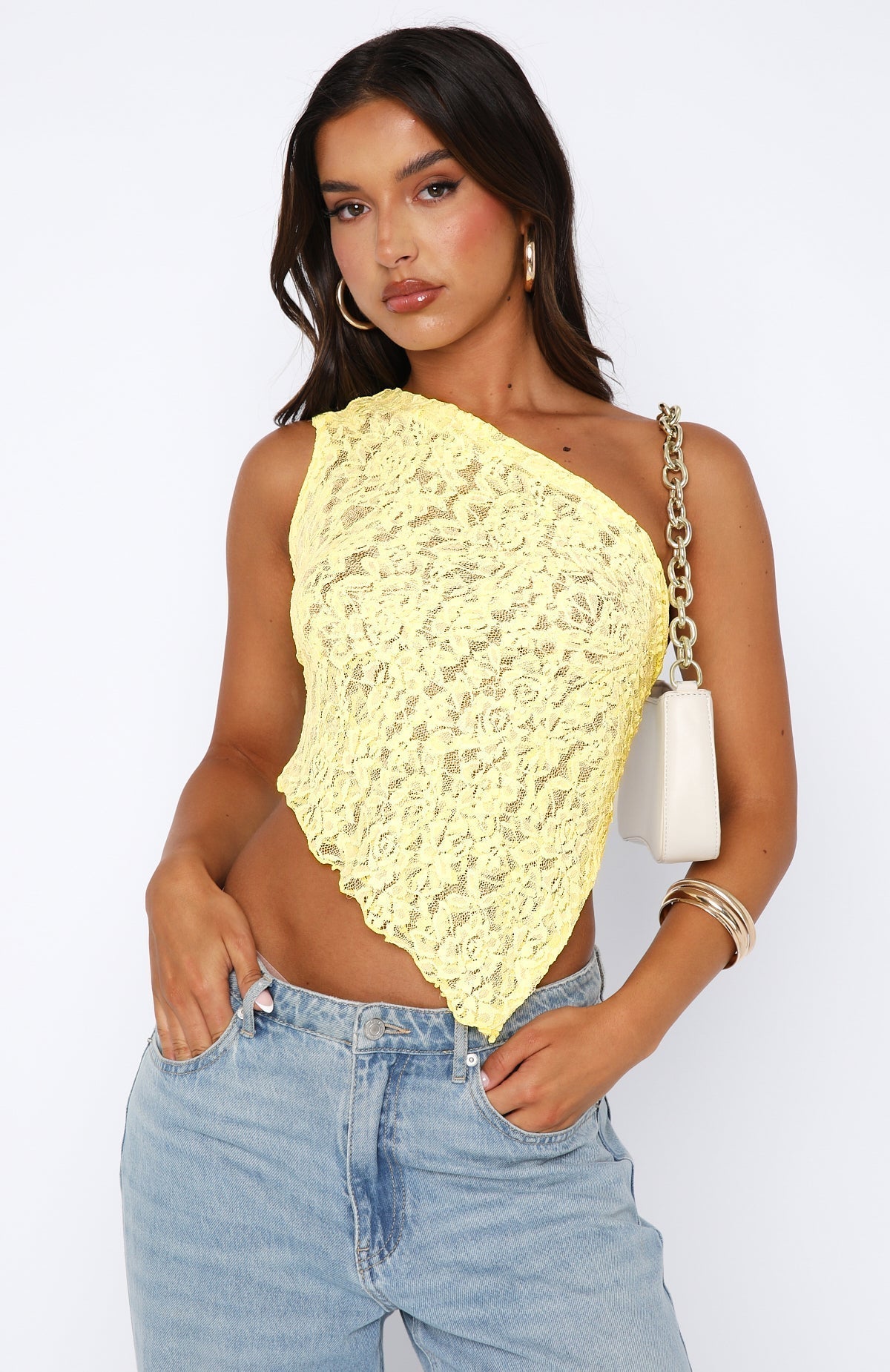 Front view of a light yellow one-shoulder lace top for women with an asymmetrical hemline.