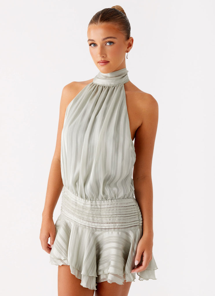 Sage green Daniela pleated mini dress with a high halter neckline and a gathered, textured waistline.