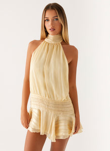 Pale yellow Daniela pleated mini dress, showcasing a high neck and a ruffled, short skirt with subtle stripes.