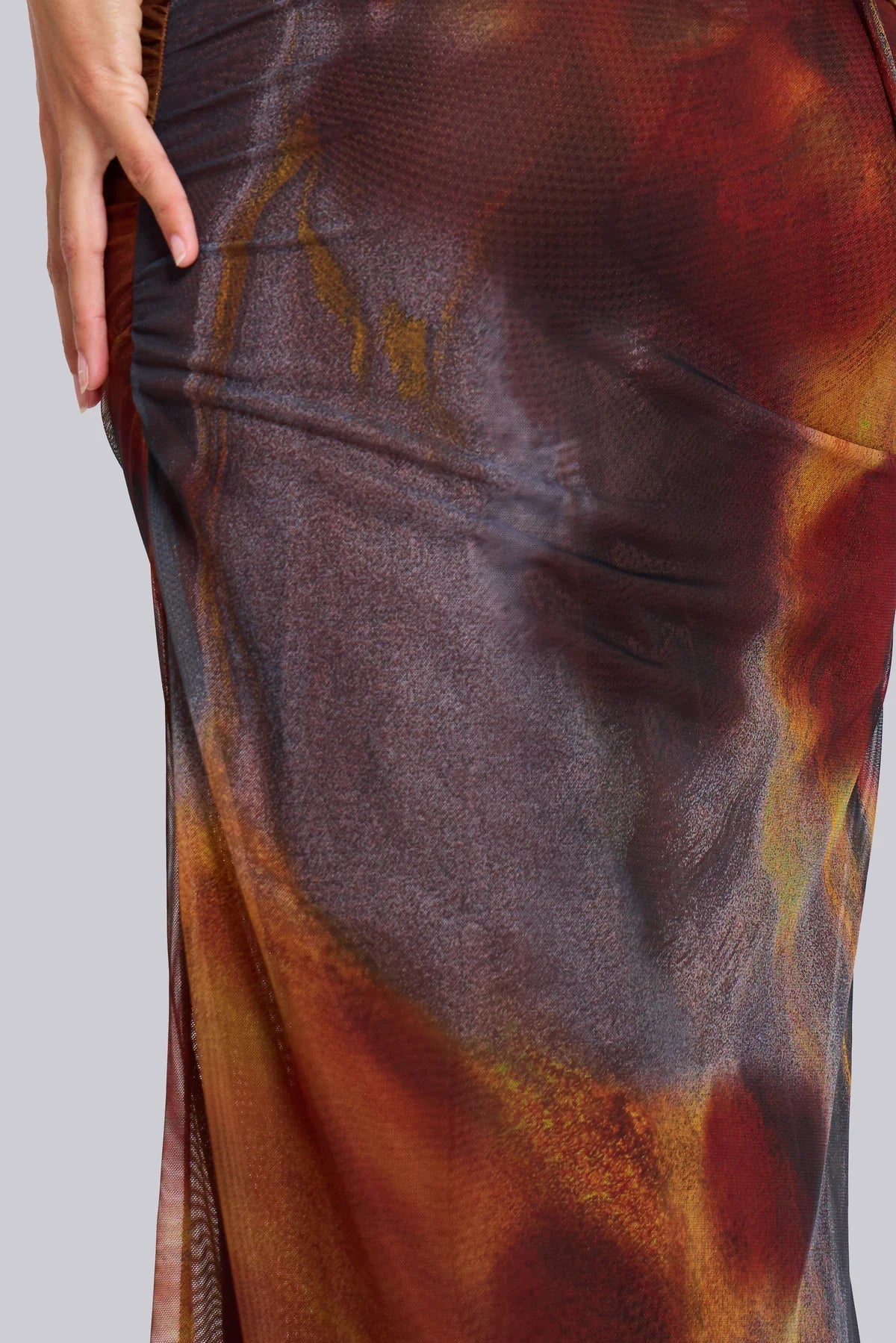 Texture and vibrant abstract pattern of the mesh fabric on the side of a women's maxi dress