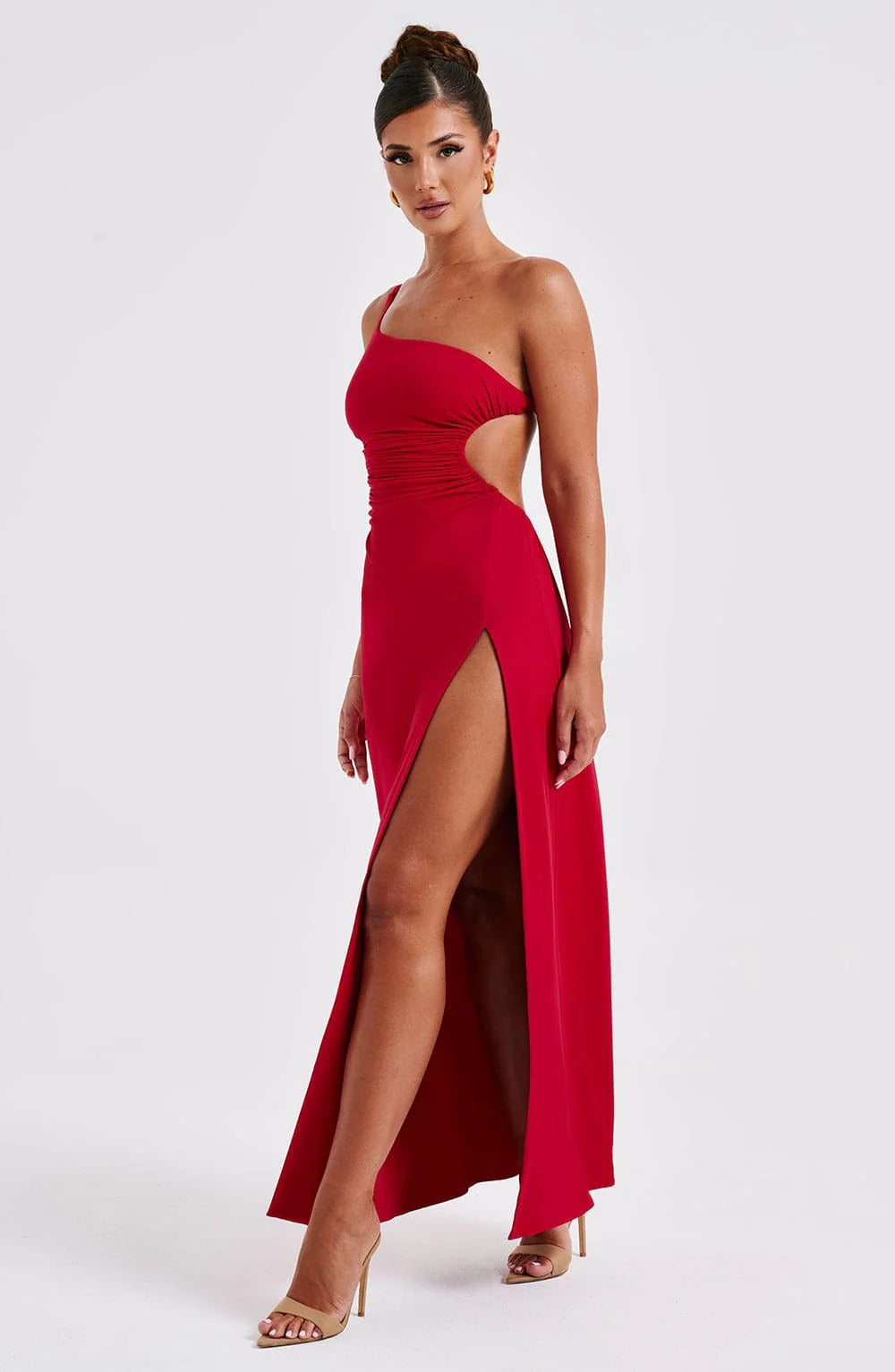 Side view of red Elara Ruched Maxi Dress, showcasing the one-shoulder style, side cut-out, and flowing slit.