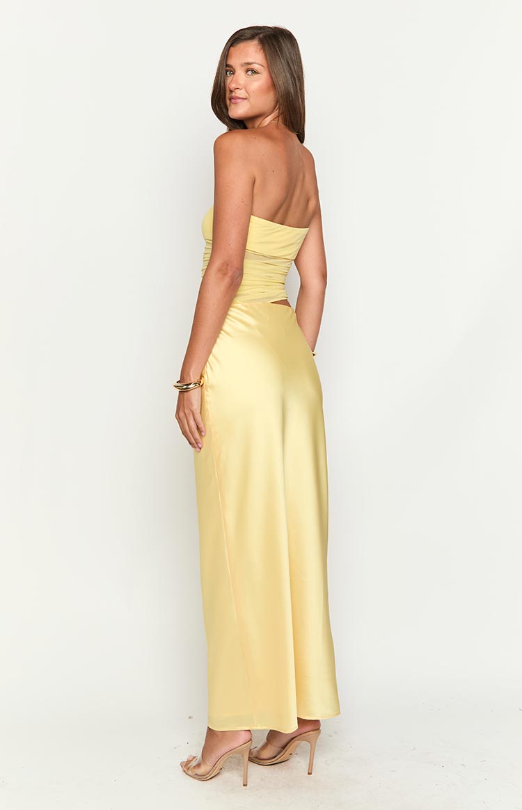 Back 3/4 view of the yellow Elinor cutout maxi dress, highlighting the smooth satin skirt and strapless design.
