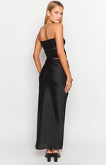 Back 3/4 view of the black Elinor cutout maxi dress, highlighting the smooth satin skirt and strapless design.