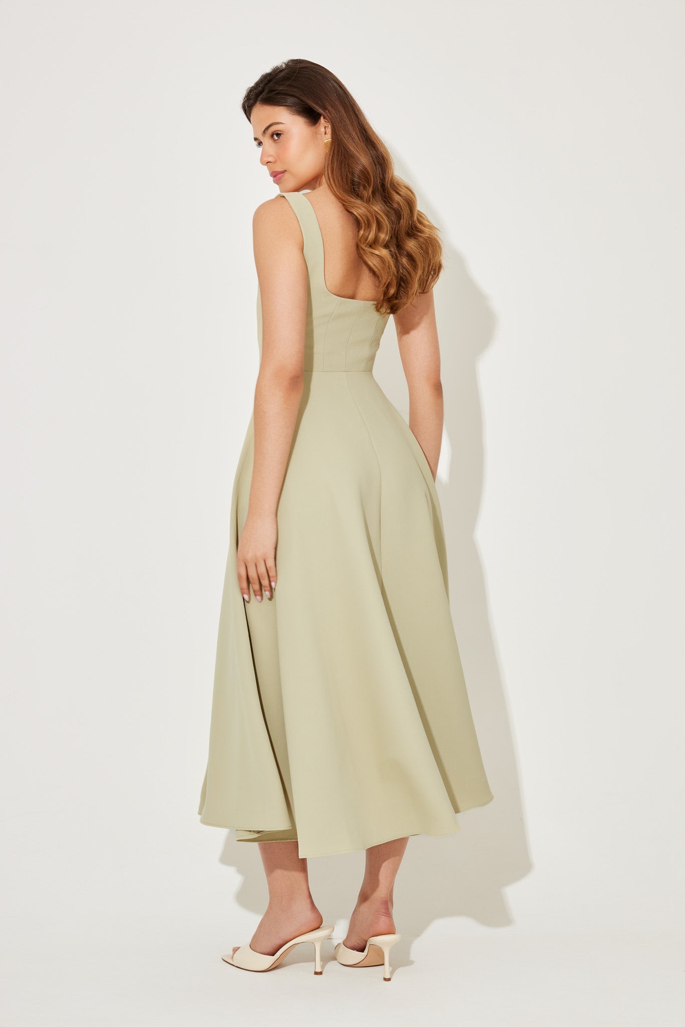 Back view of the Eliza A-line midi dress in light sage green, showing the full skirt and square back.