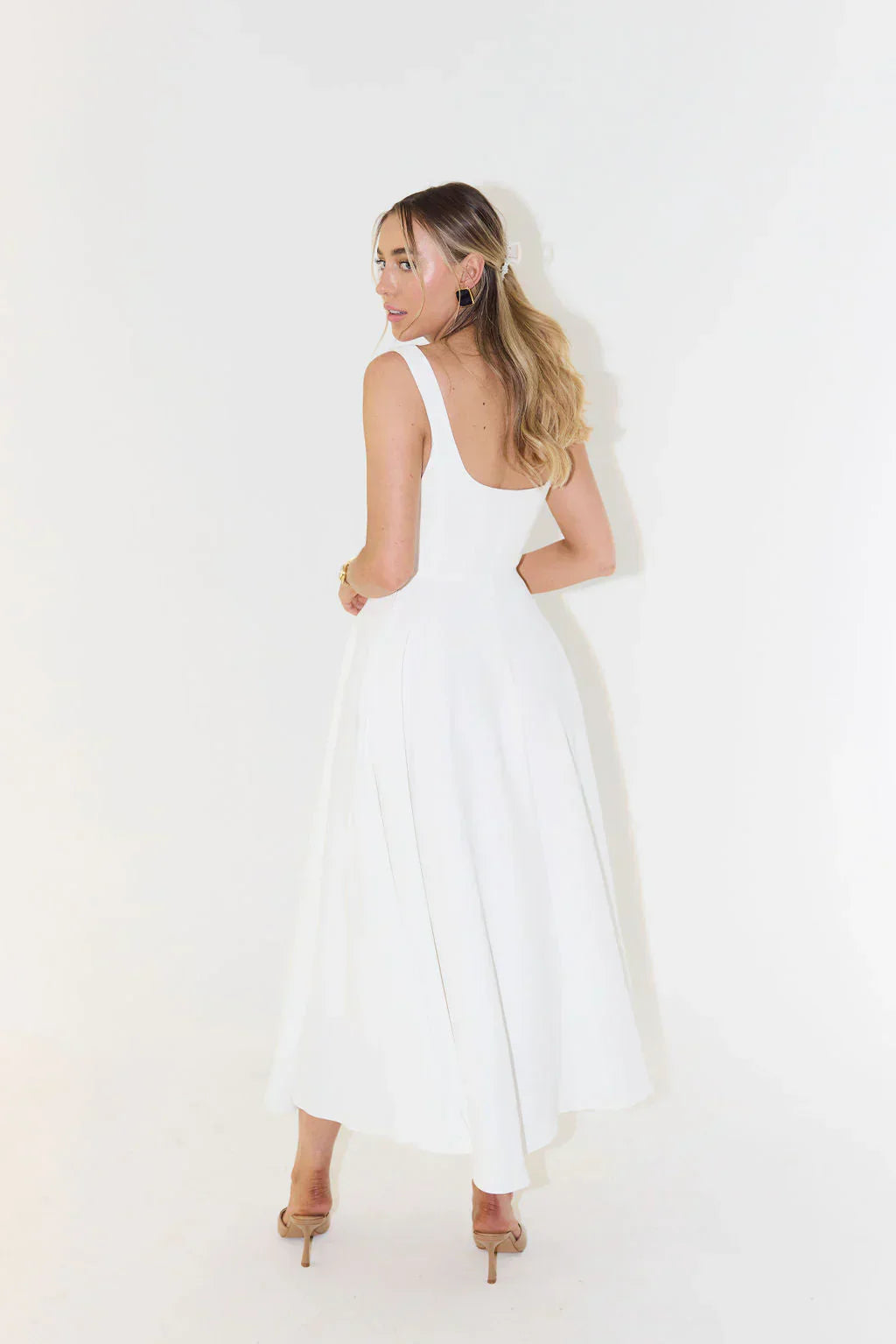 Three-quarter back view of the Eliza A-line midi dress in white, with a slight turn, highlighting the full skirt and square back.