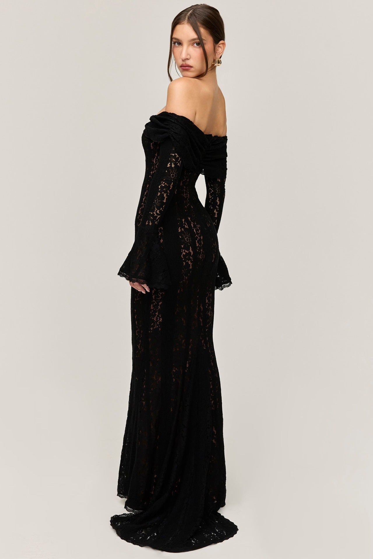 Three-quarter back view of the black lace maxi dress, showcasing the off-the-shoulder design and the subtle train.