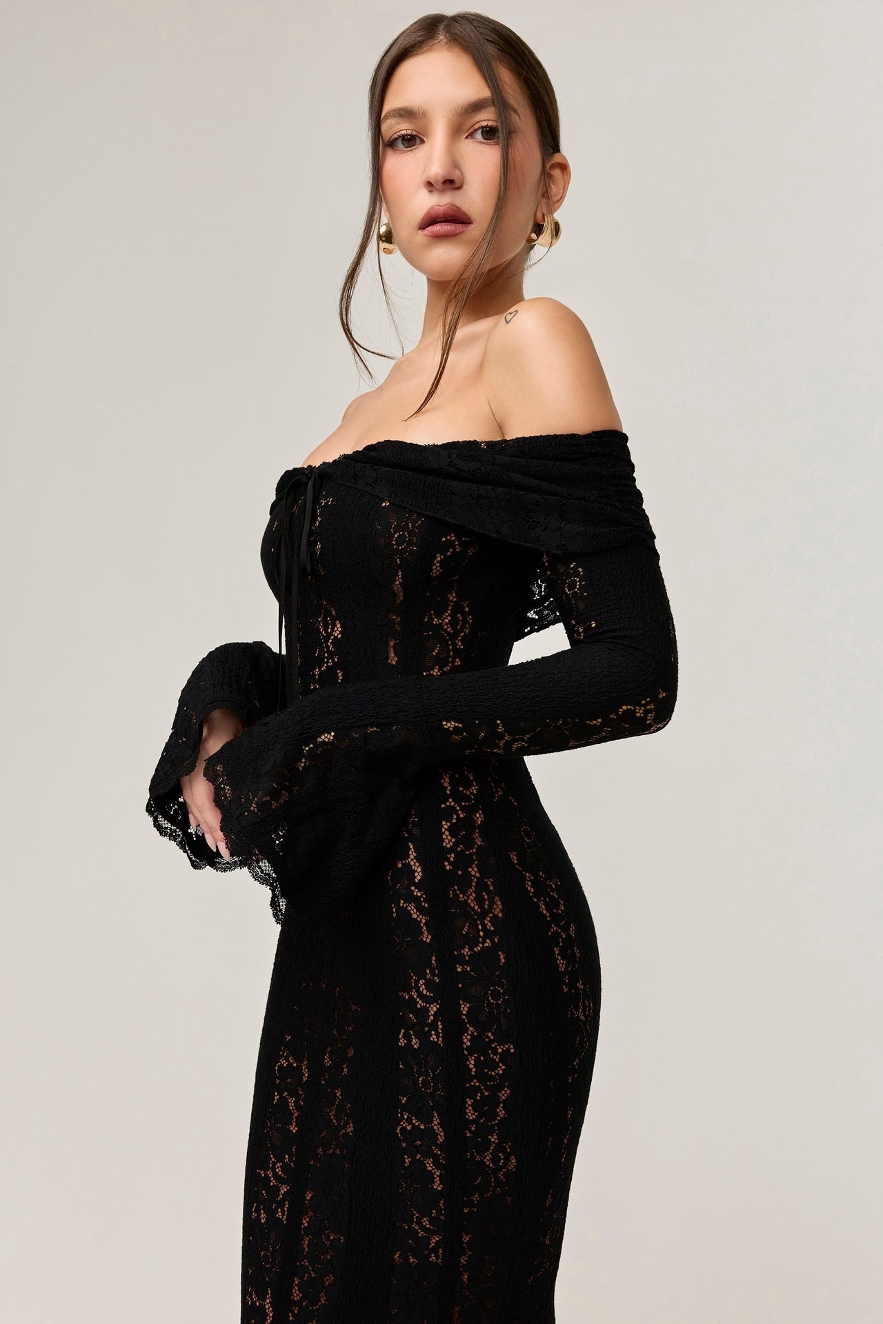 Close-up of the black lace maxi dress, emphasizing the off-the-shoulder ruffles, tie-front detail, and delicate lace fabric.