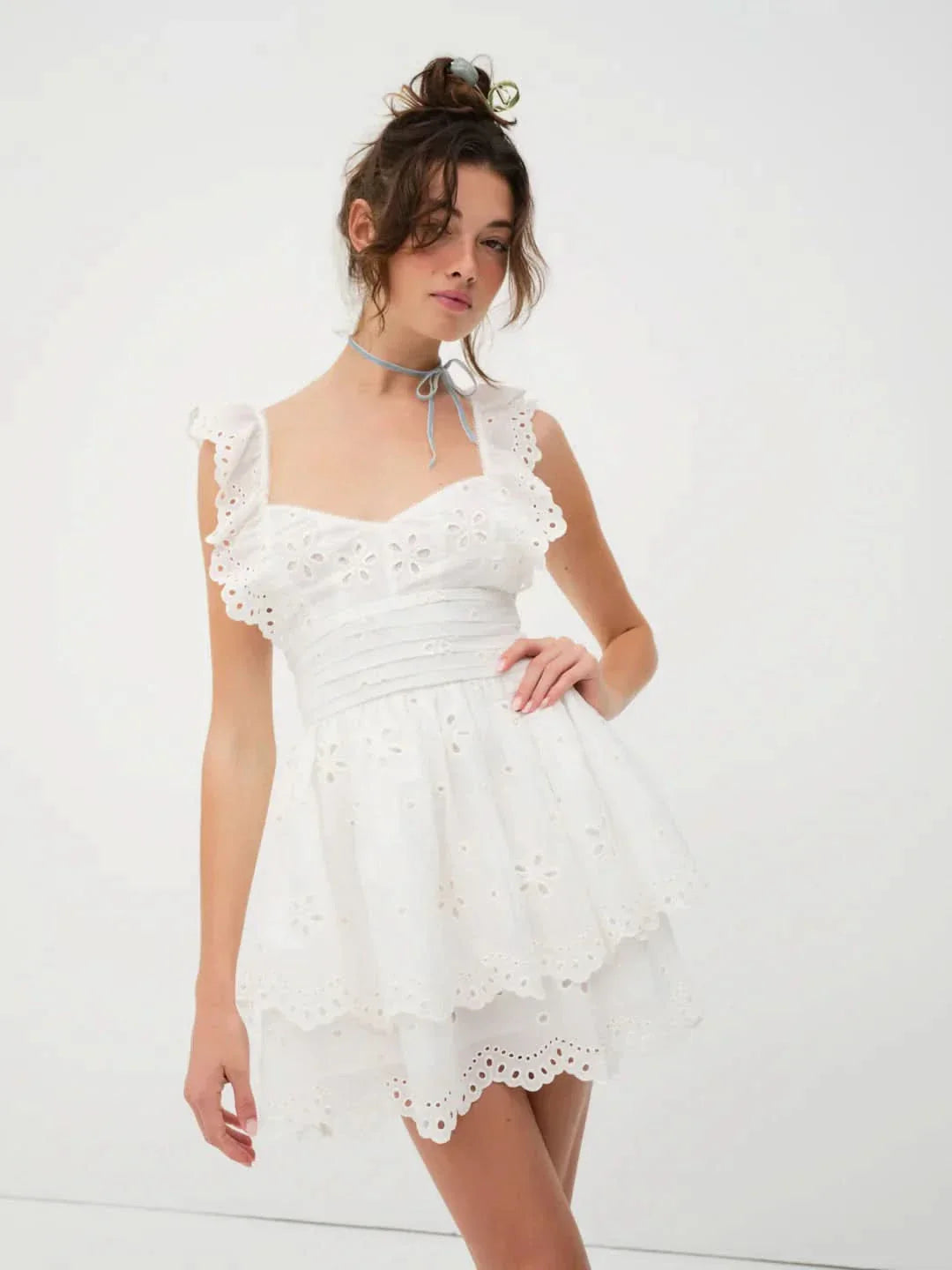 Front view of white eyelet mini dress with sweet heart neckline and ruffled details for women