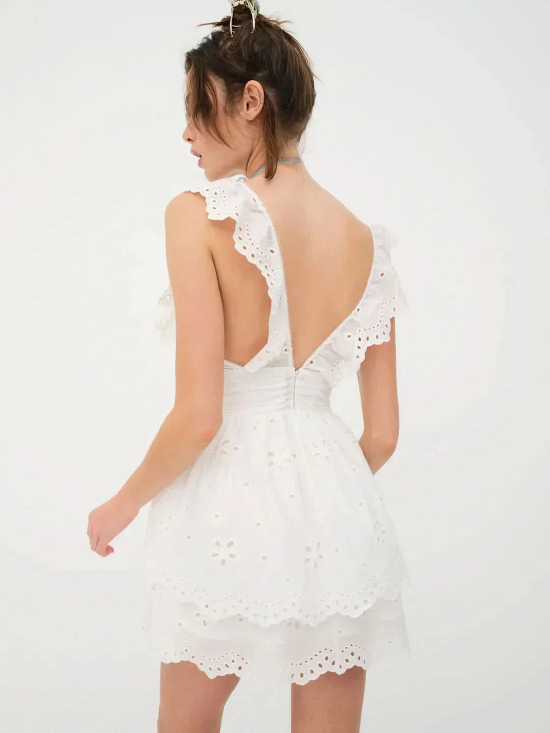 Back view of white eyelet mini dress showing low V-back and ruffled straps for women