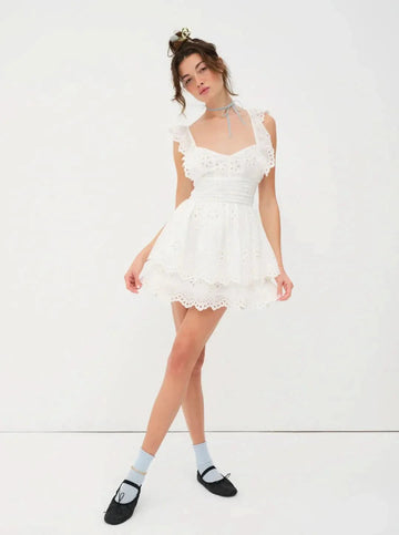 White eyelet mini dress with ruffled straps and tiered skirt for women, styled with a light blue choker