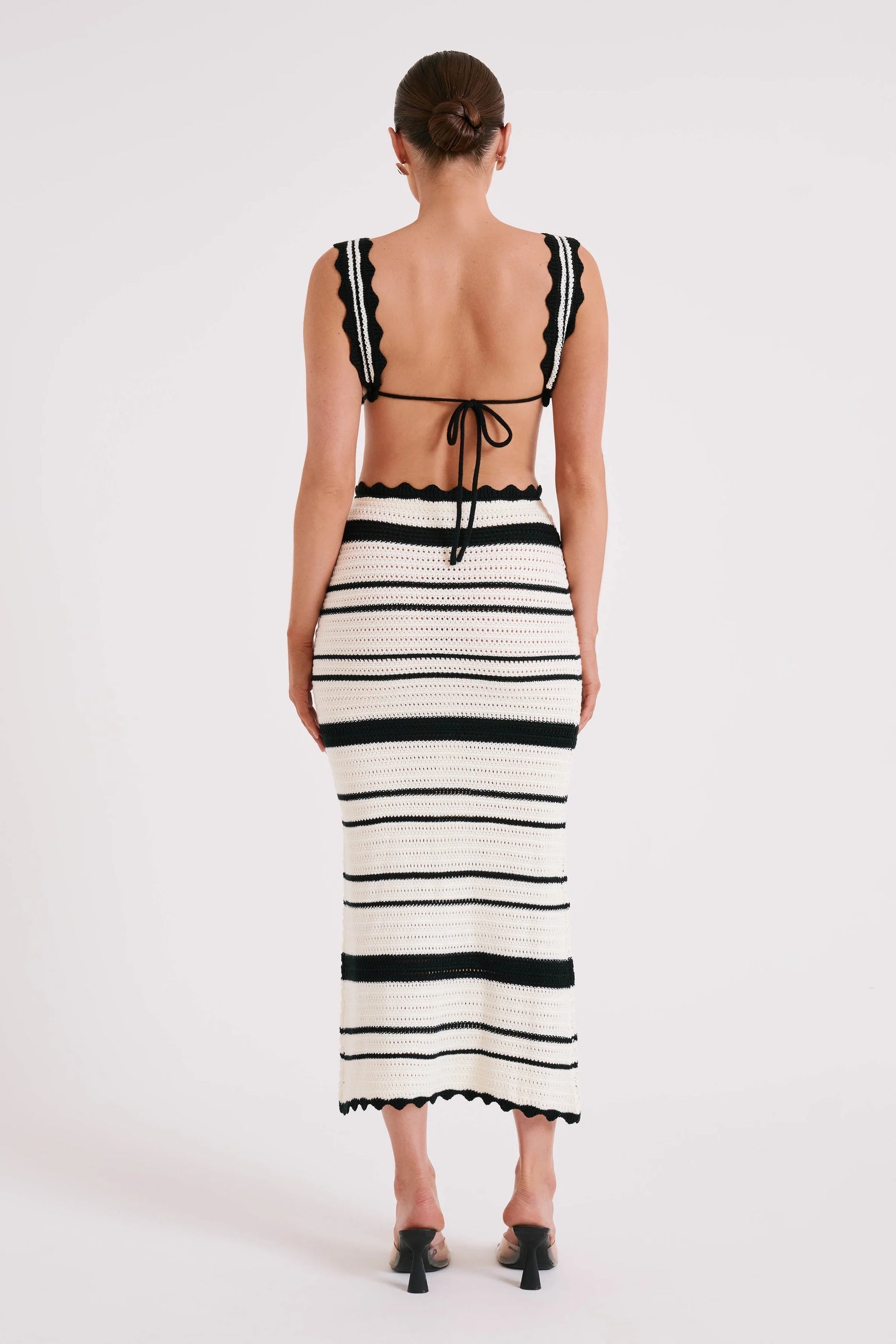Back view of a white and black striped crochet maxi set, highlighting the tie-back bralette and long skirt.