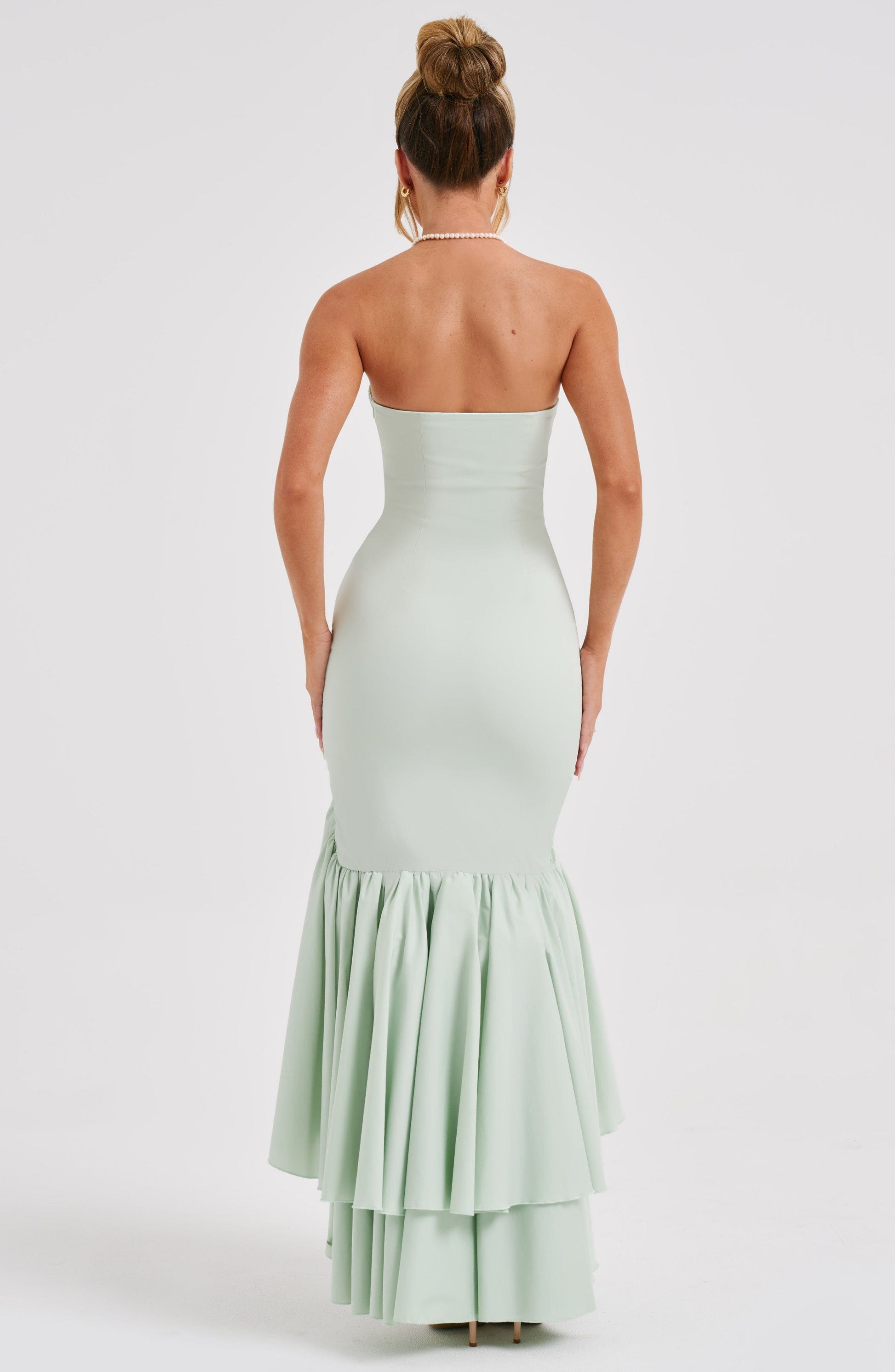 Back view of the mint green strapless maxi dress, showing the fitted bodice and tiered ruffled skirt.