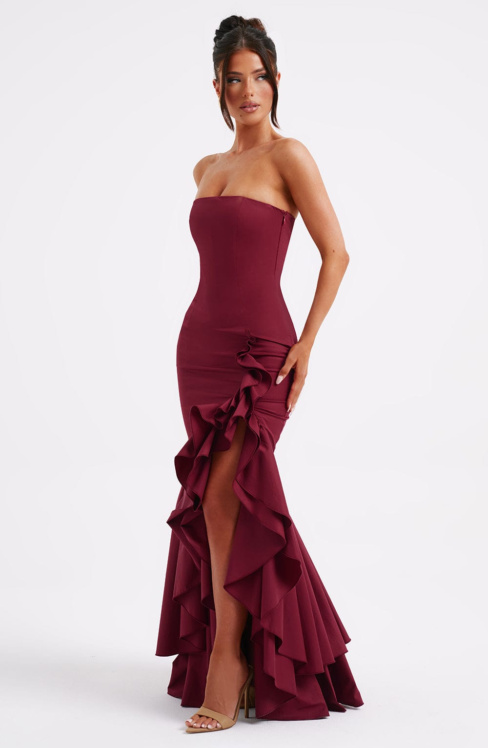 Front view of a strapless burgundy Emily Ruffle Maxi Dress with a high-low hem and dramatic side ruffles.