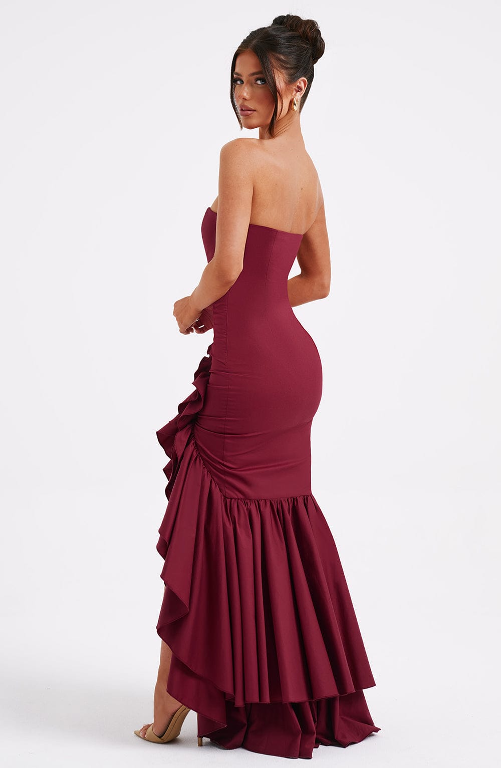 Side view of the deep red Emily Ruffle Maxi Dress, highlighting the fitted bodice and voluminous ruffled skirt.