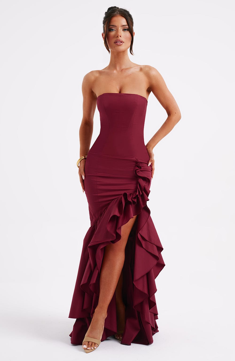 Front view of a strapless burgundy Emily Ruffle Maxi Dress with a high-low hem and dramatic side ruffles.