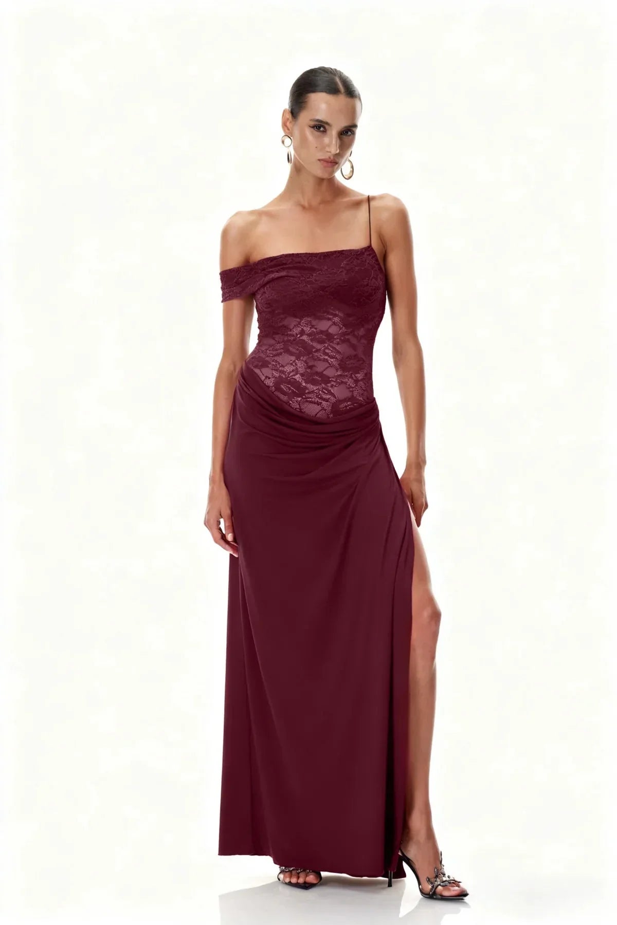 Studio shot of Emmalyn Lace Maxi Dress in deep burgundy, featuring a high leg slit and an off-shoulder lace top.