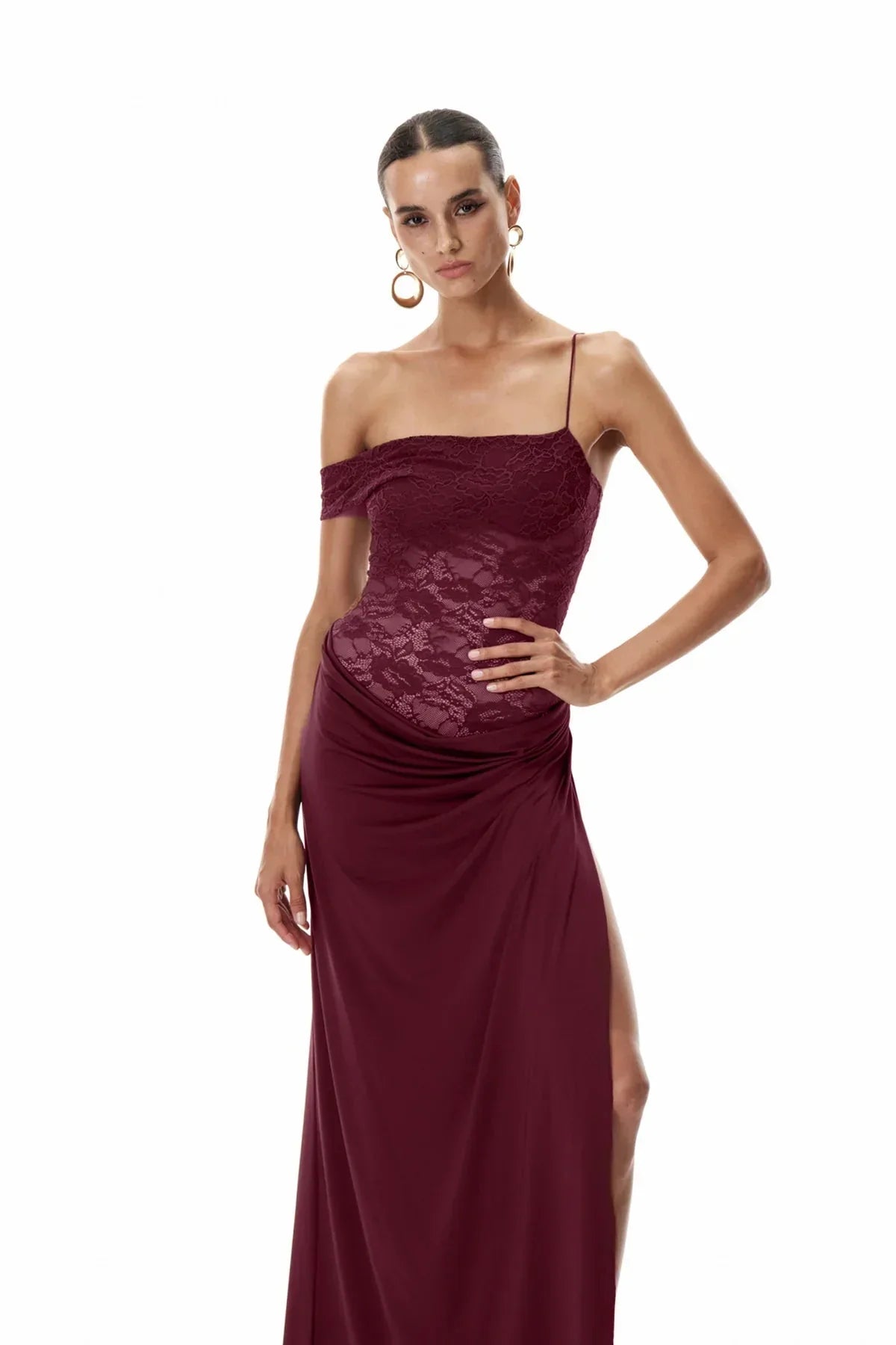 Three-quarter pose of the Emmalyn Lace Maxi Dress in burgundy, displaying the form-fitting lace bodice and flowing skirt.