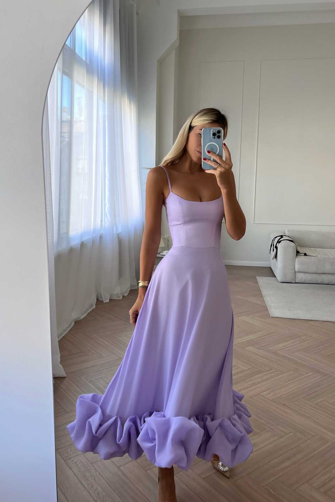 Lavender midi dress with thin straps and a large ruffled hem, reflected in a mirror indoors.