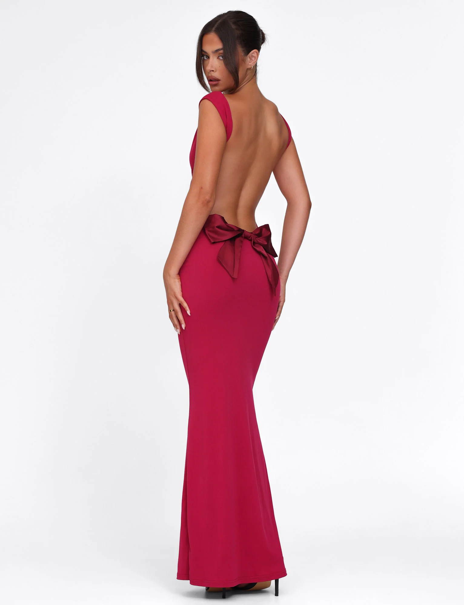 Three-quarter back view of the deep red Emmie Bow Maxi Dress, highlighting the low back and elegant bow.