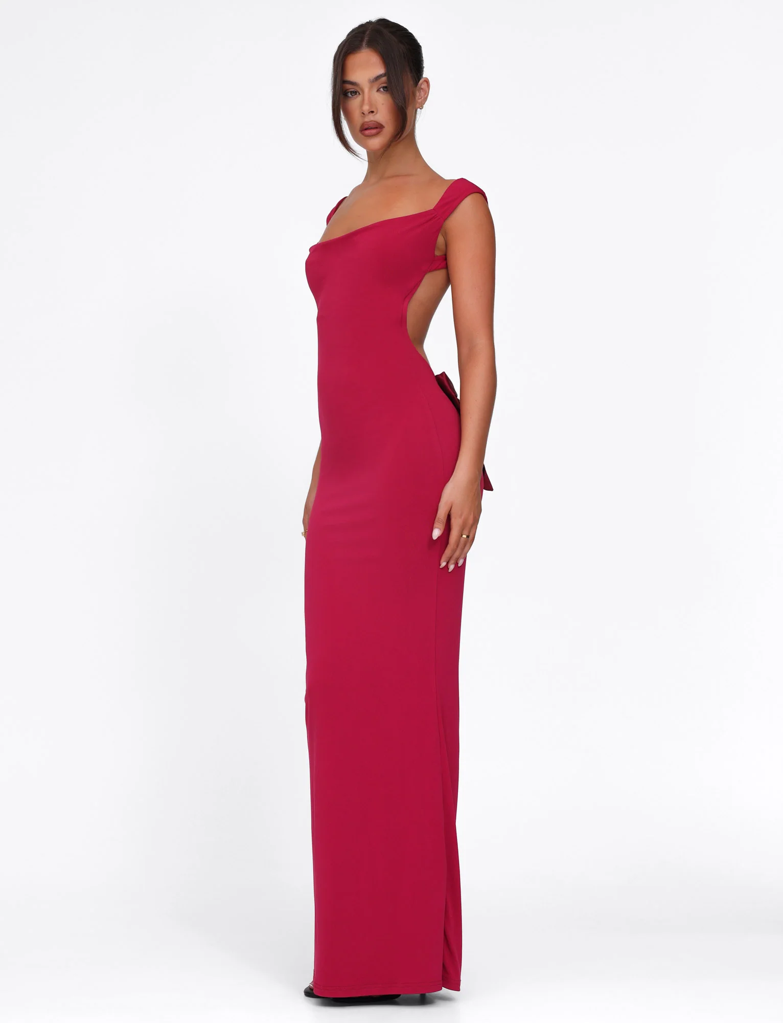 Side view of a deep red Emmie Bow Maxi Dress, showing the off-shoulder neckline and a subtle side slit.