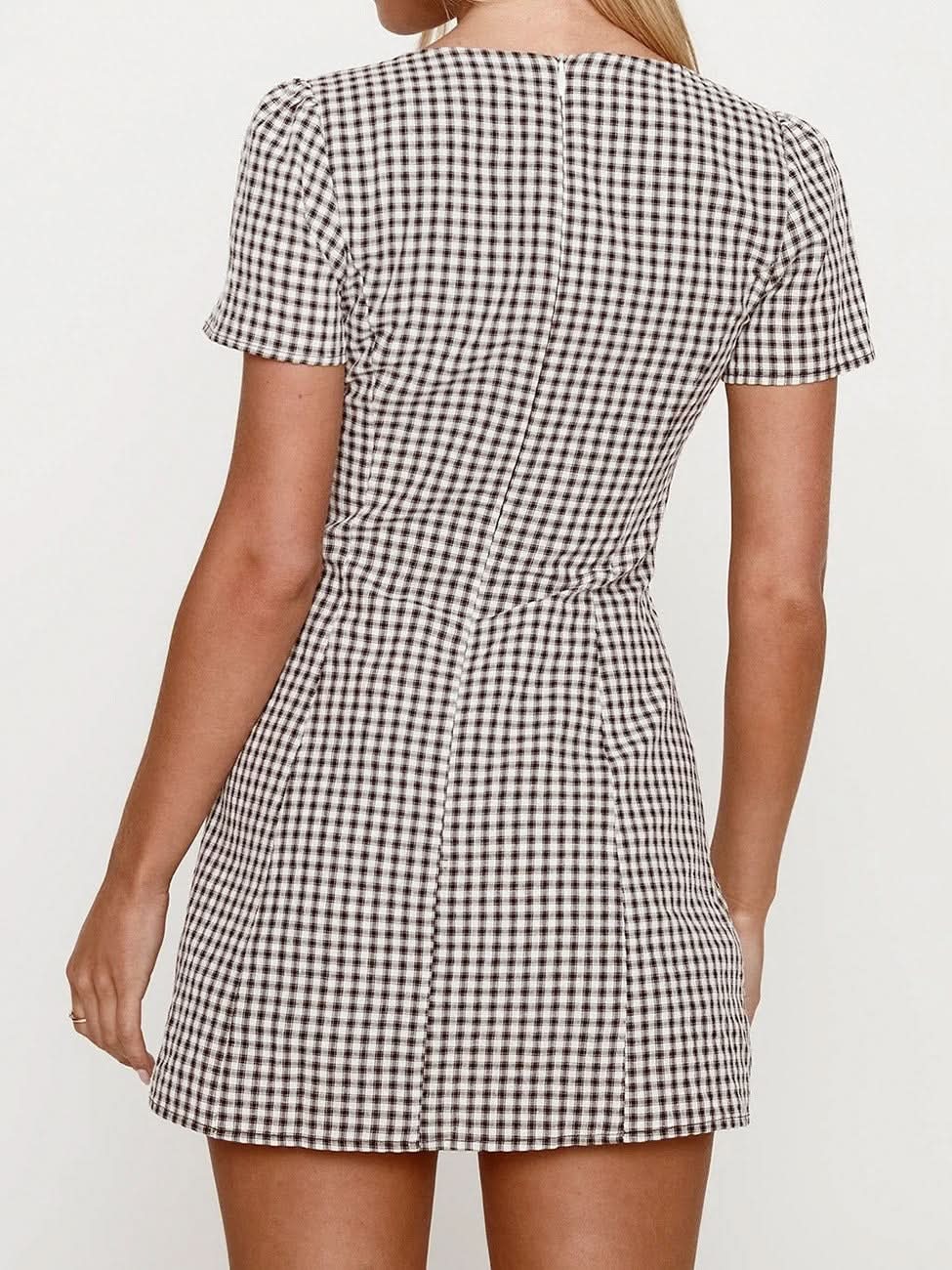 Back view of the black and white gingham Fallon Check Mini Dress, featuring short sleeves and a subtle pleat at the back of the skirt.