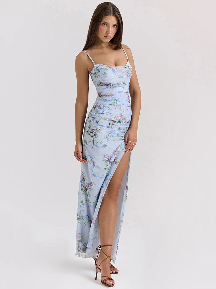 Light blue floral maxi dress with spaghetti straps and ruched detailing, thigh-high slit, and delicate purple flowers.