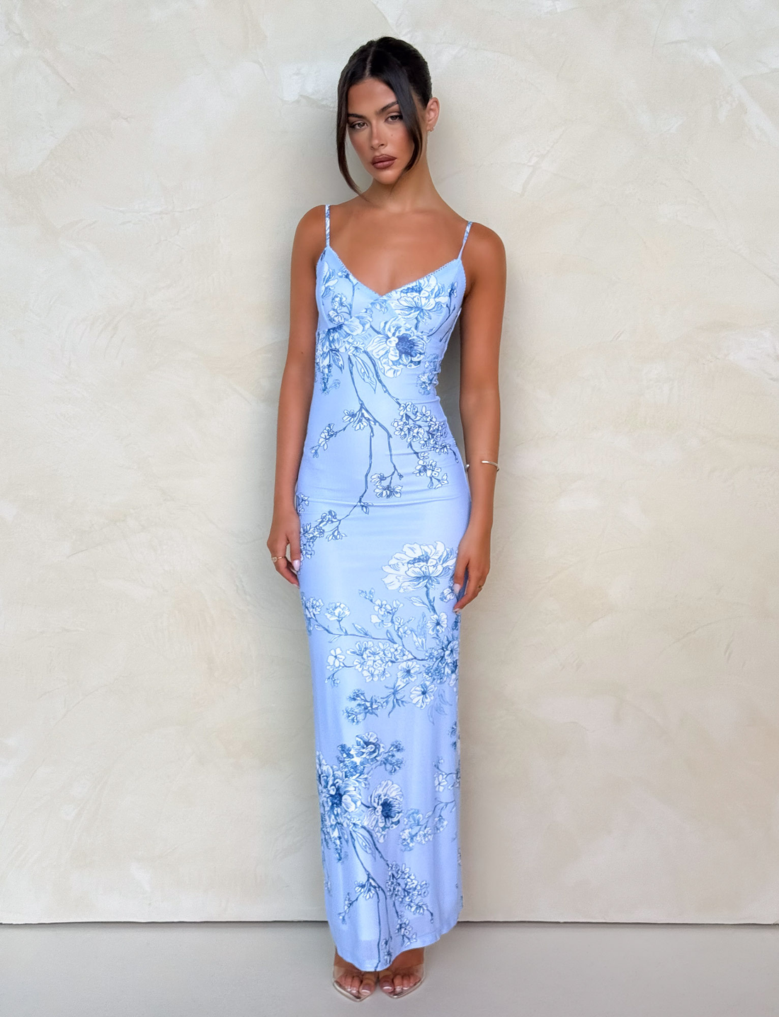 Light blue floral maxi dress with delicate spaghetti straps and v-neckline, featuring white and navy floral patterns.