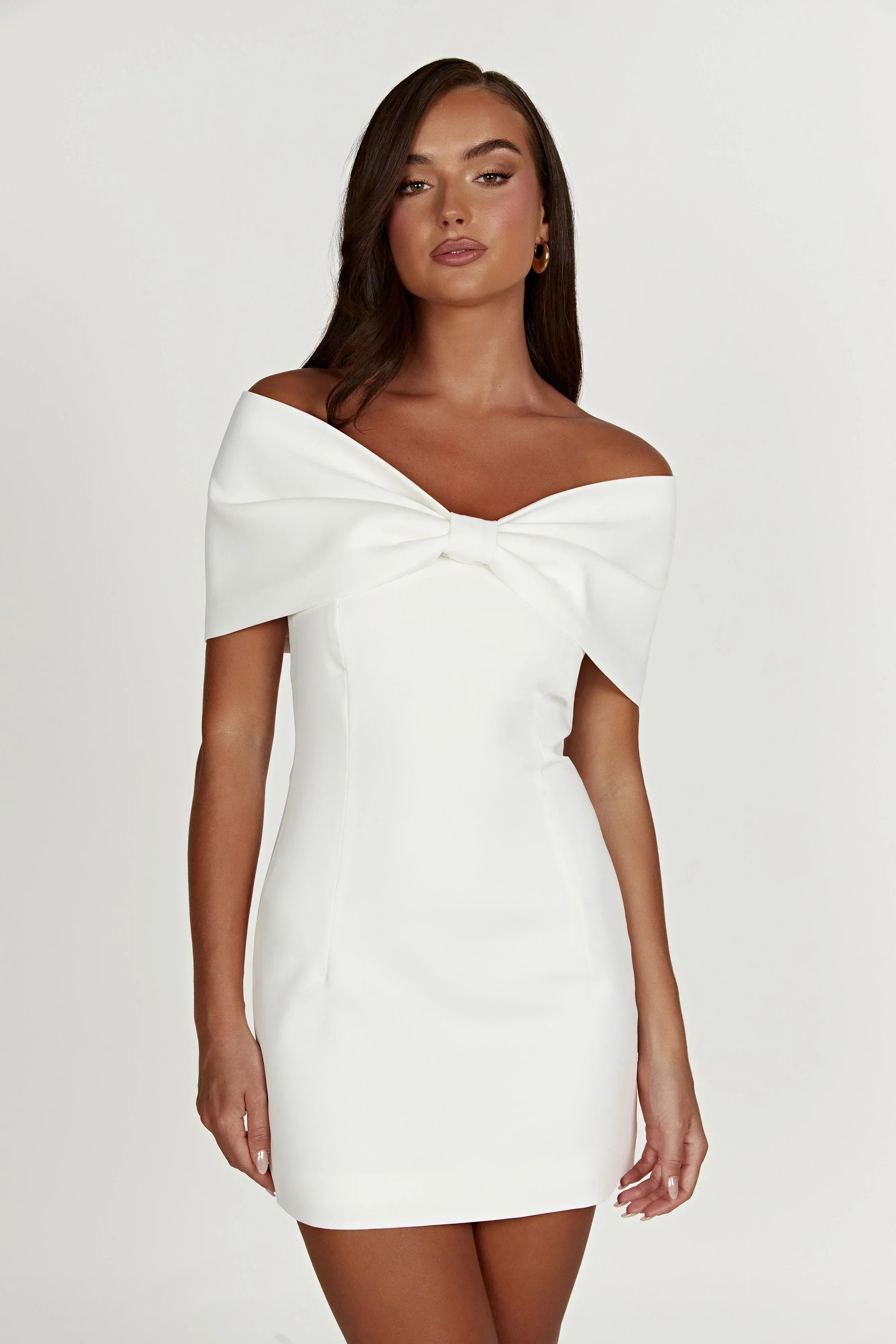 White Freya Bow Mini Dress, off-the-shoulder with a structured bow detail, shown on a model.