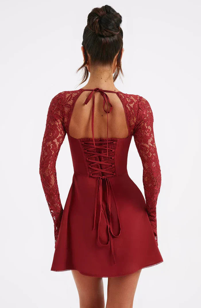 Rear view of a dark red mini dress featuring long lace sleeves and a laced-up corset back with tie closures.