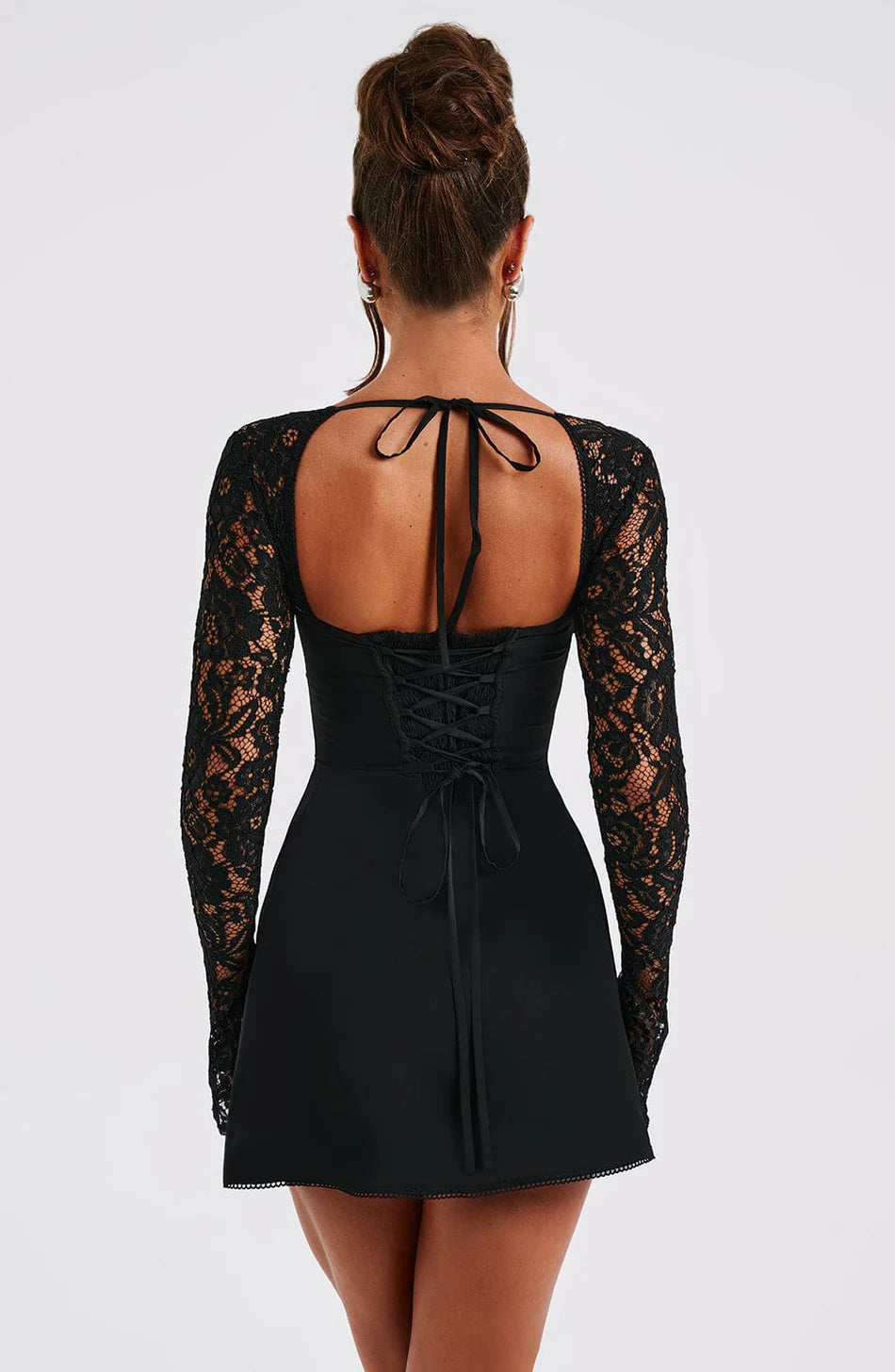 Direct back view of a black mini dress with long sheer lace sleeves and a detailed corset-style tie-up back.