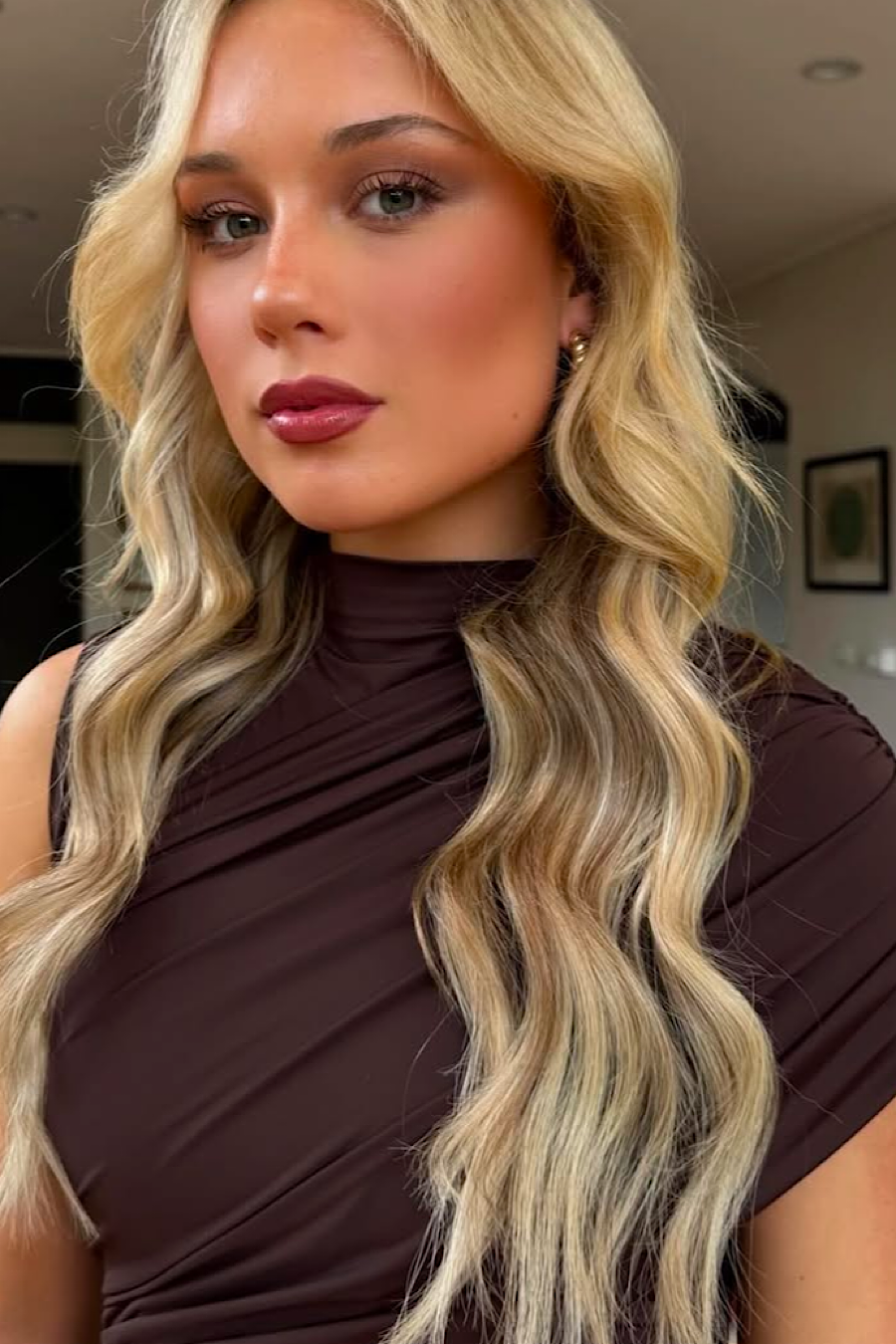 Close-up of the neckline and shoulder detail of the brown ruched mini dress on a blonde woman.