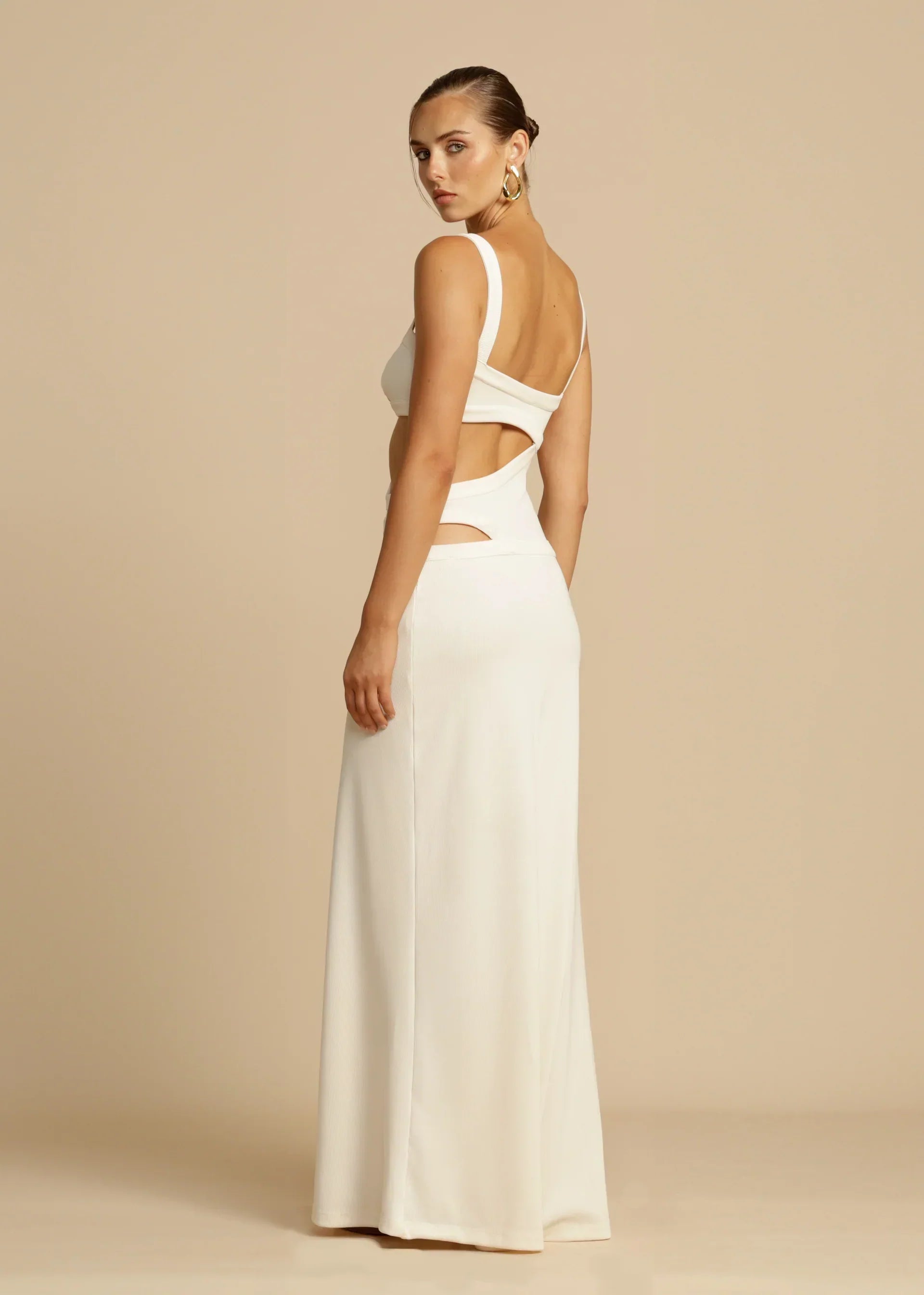 Back view of the white Haisley cutout maxi dress, showcasing the side and back cutouts, on a light background.