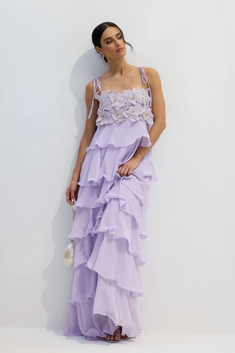 Side profile of the lavender Hattie tiered maxi dress, showcasing the ruffle details and floral embellished top.