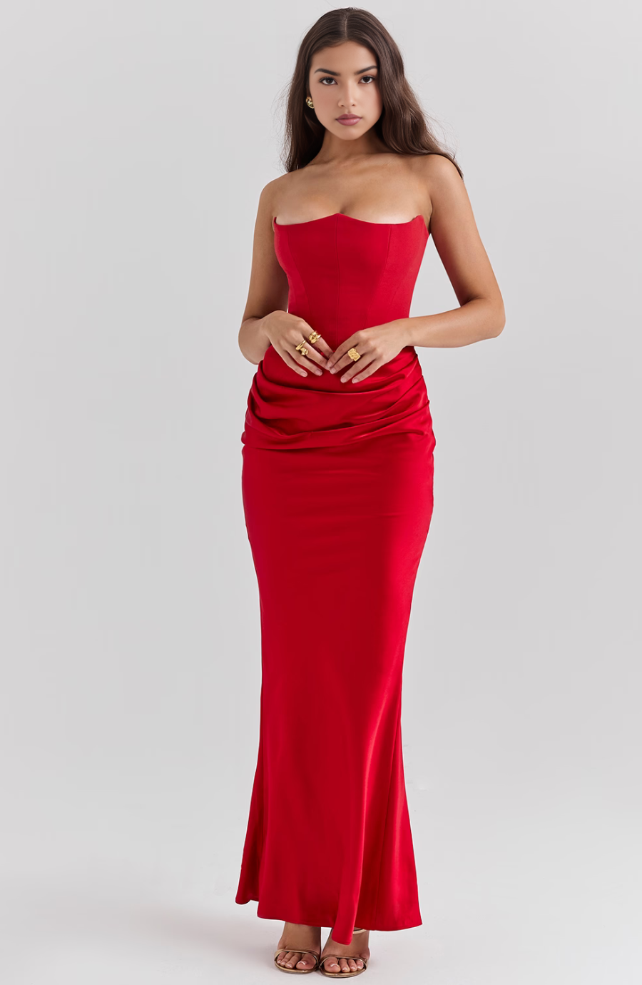 Full-length red corset maxi dress with sweetheart neckline and ruched waist detail, worn by a woman facing forward.