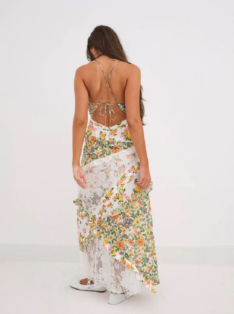 Back view of the Iris Tiered Maxi Dress in a vibrant yellow and green floral print with white lace accents and criss-cross straps.