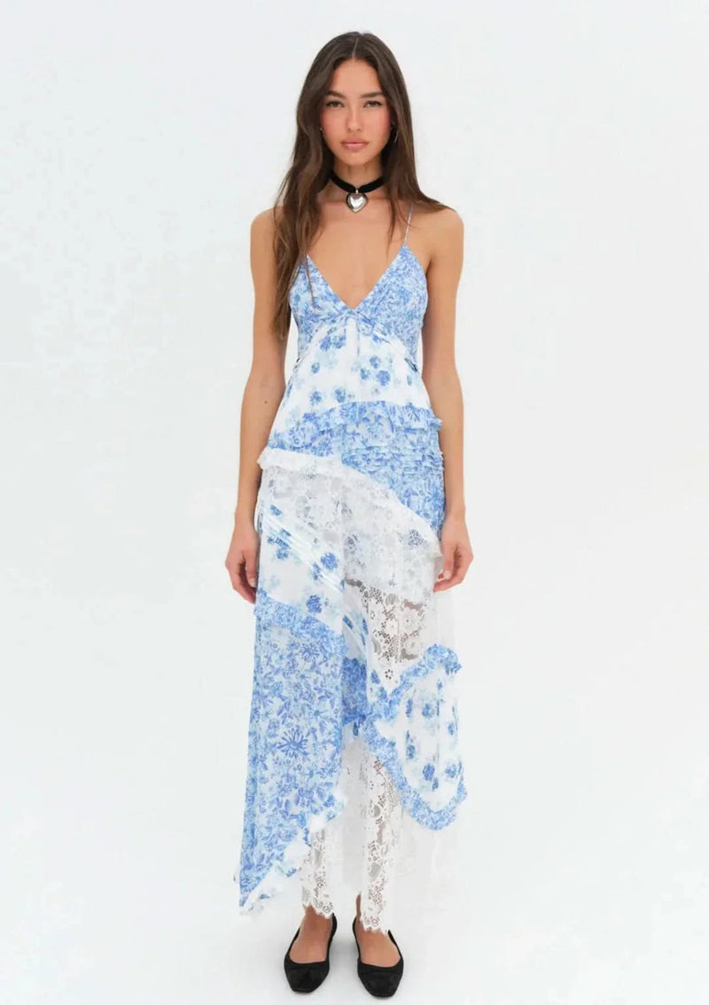 Front view of an Iris Tiered Maxi Dress featuring blue floral print and white lace panels, with spaghetti straps and a v-neckline.