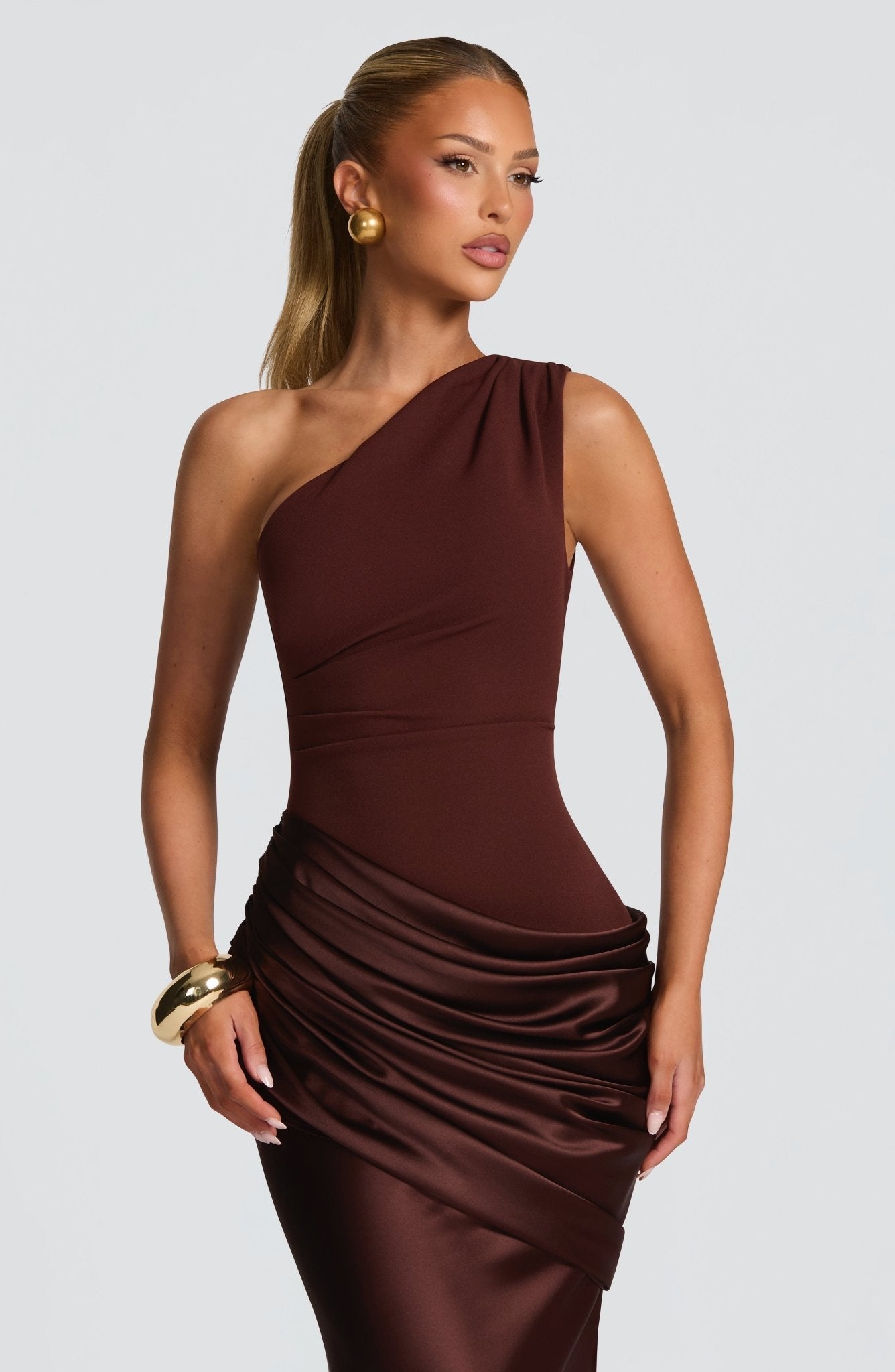 Close-up of the brown Isabelle Draped Maxi Dress, showing the intricate draping on the satin skirt and one-shoulder detail.