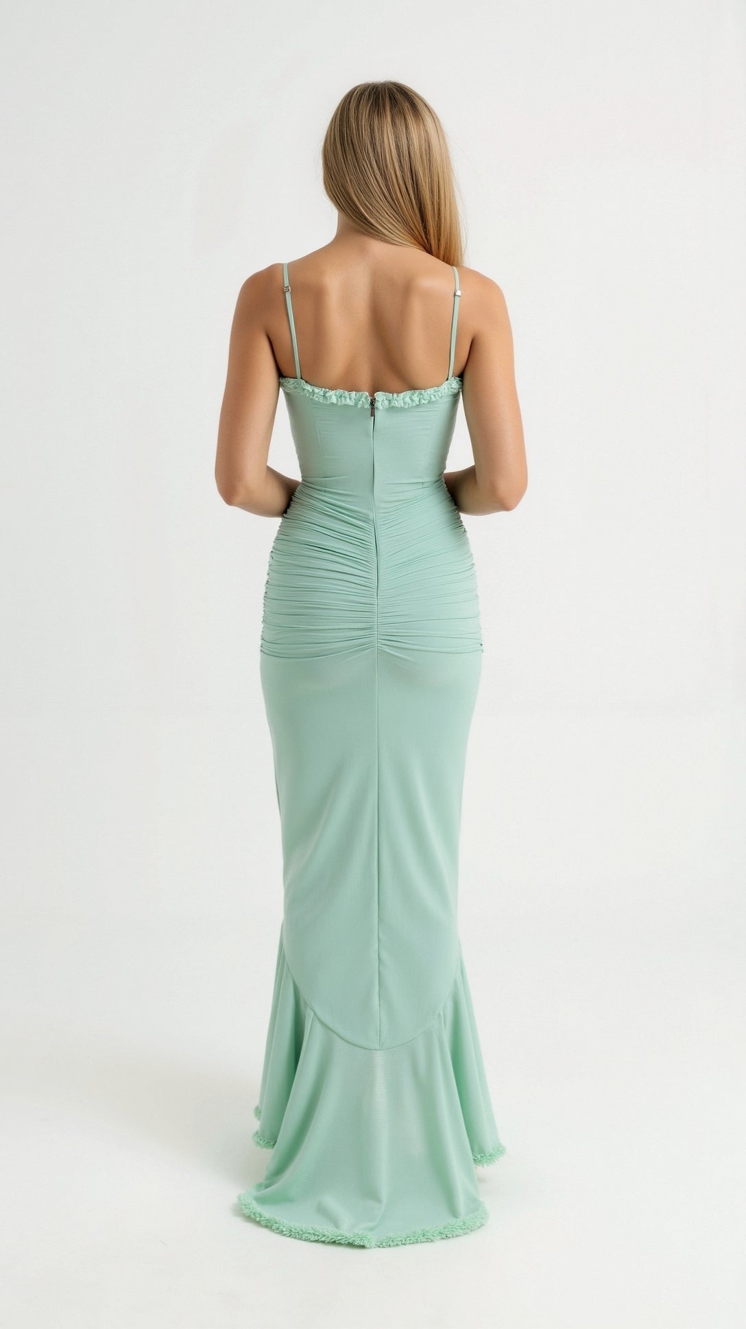Back view of a woman wearing a light mint green Isla Ruffle Maxi Dress with spaghetti straps and ruched detailing on the back.
