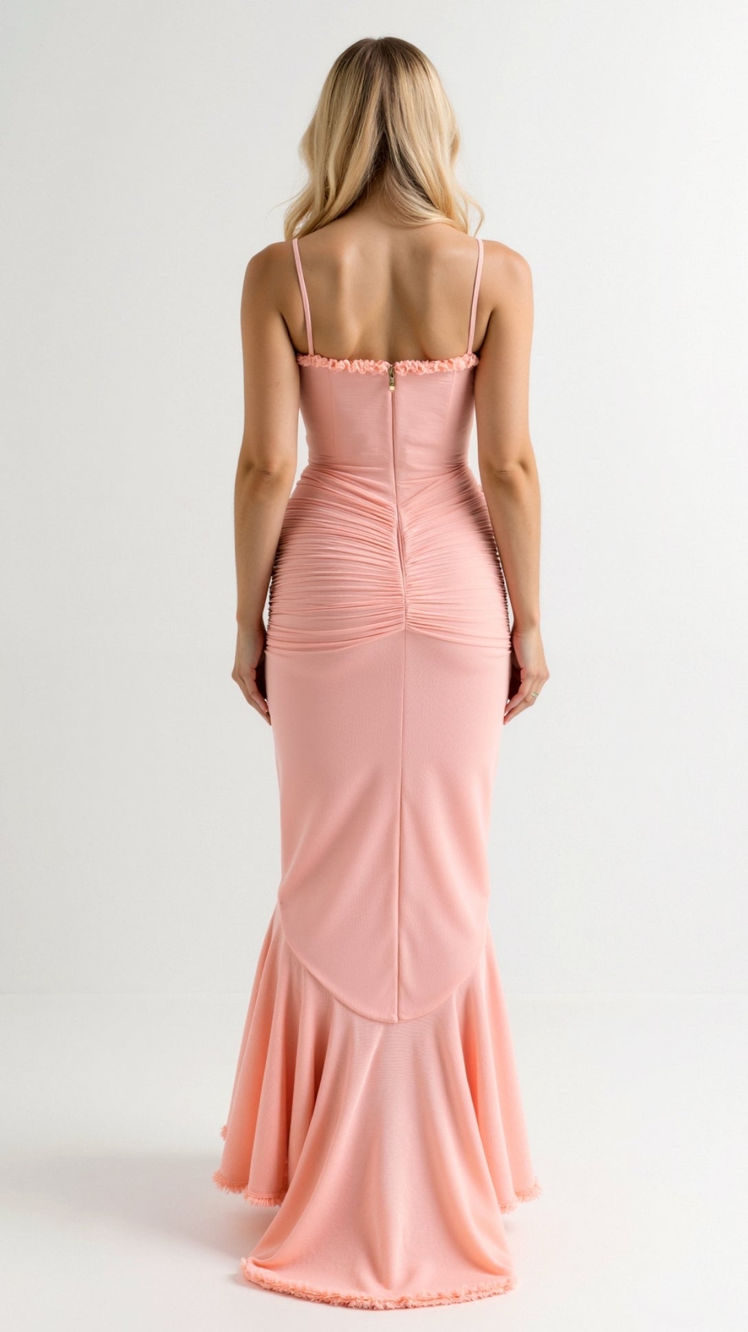 Back view of a peach pink Isla Ruffle Maxi Dress, showcasing the form-fitting design and flared ruffled hem.