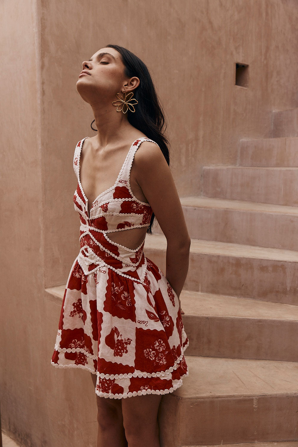 Red and white patterned Ivy Cutout Mini Dress with scalloped trim, side cutouts, and a deep V-neckline.