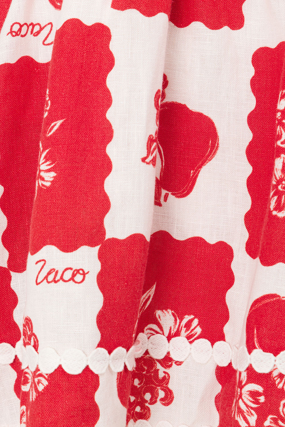 Detailed close-up of the red and white pattern on the Ivy Cutout Mini Dress, featuring floral designs and 'taco' text.
