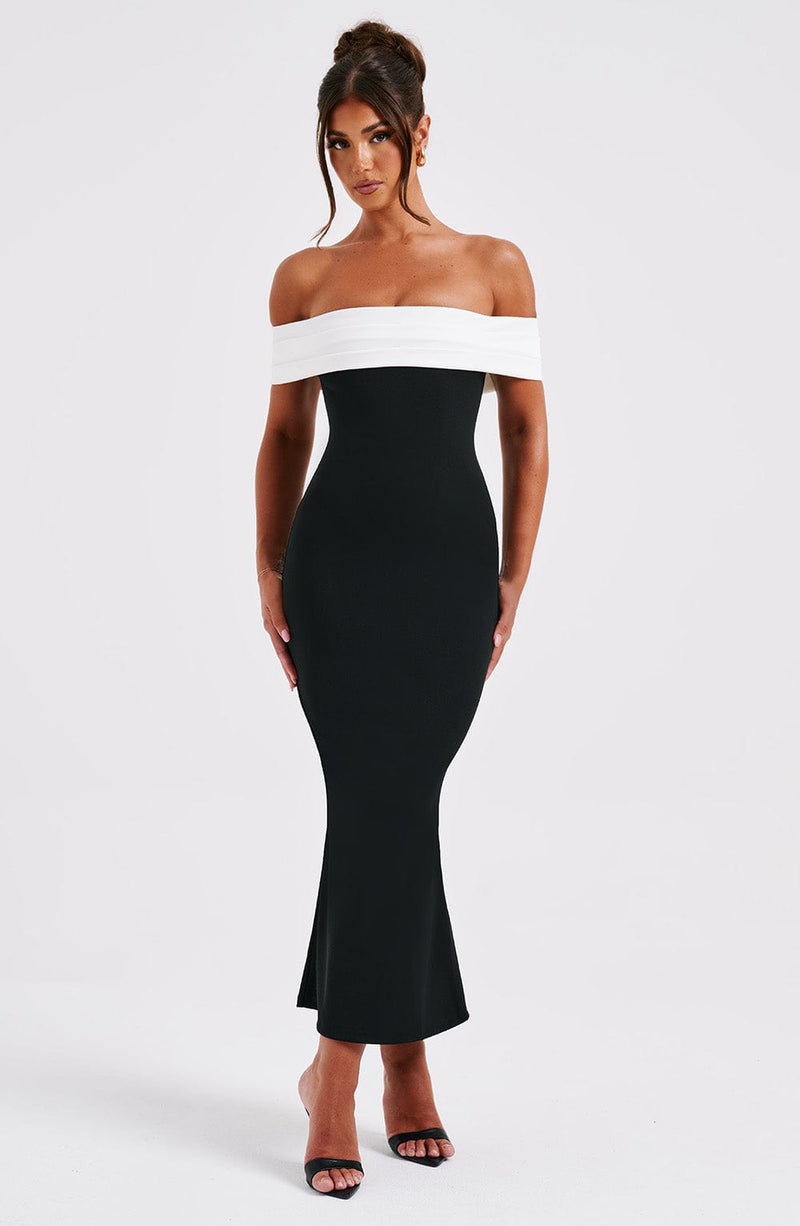 Black off-the-shoulder midi dress with a white folded neckline, form-fitting silhouette, and subtle flare at the hem.